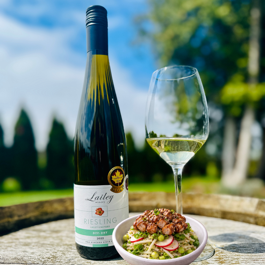 A bottle of Riesling from Lailey winery with a chicken salad and glass of wine