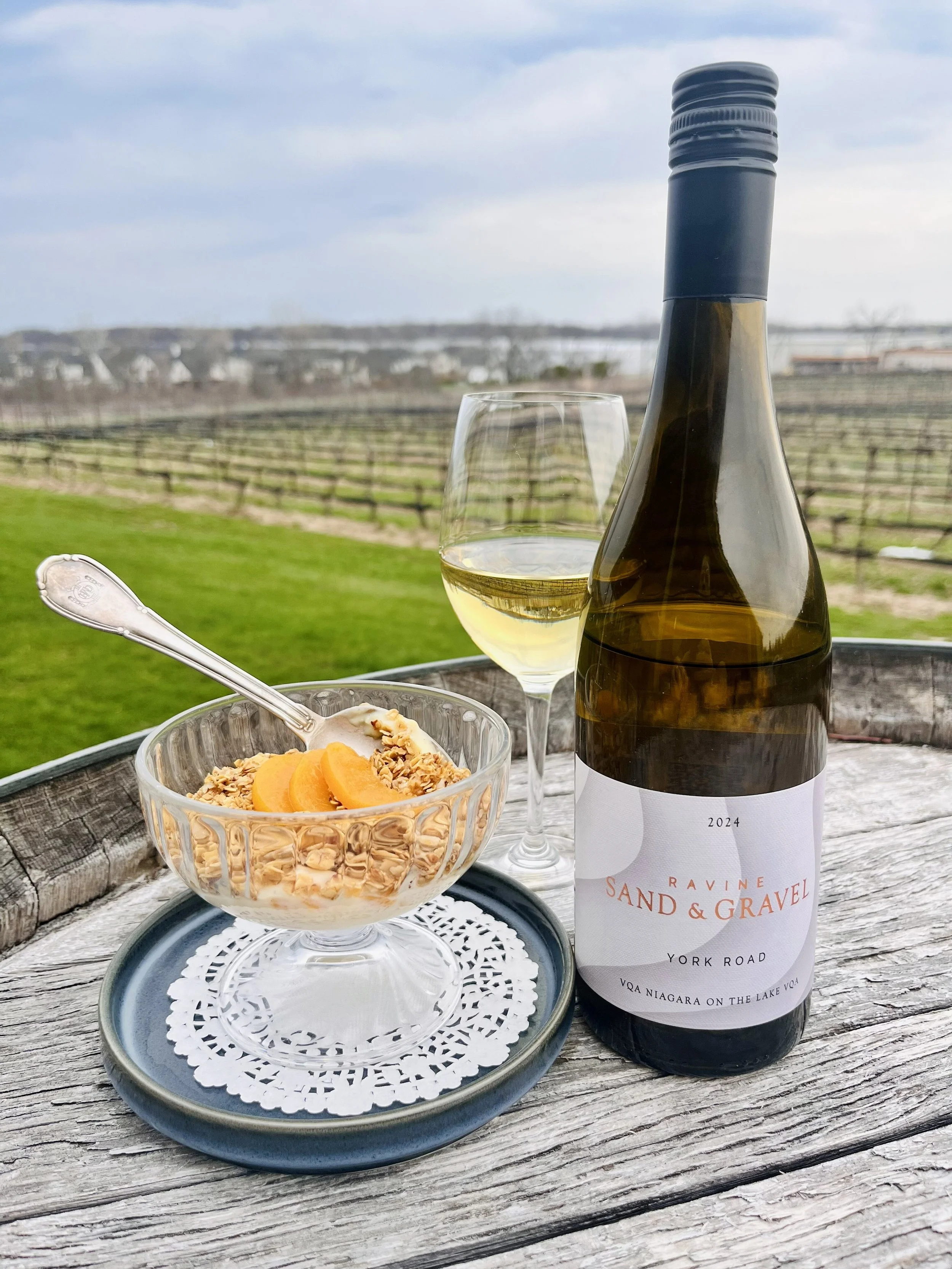 A bowl of peach custard and a glass of Ravine Wine