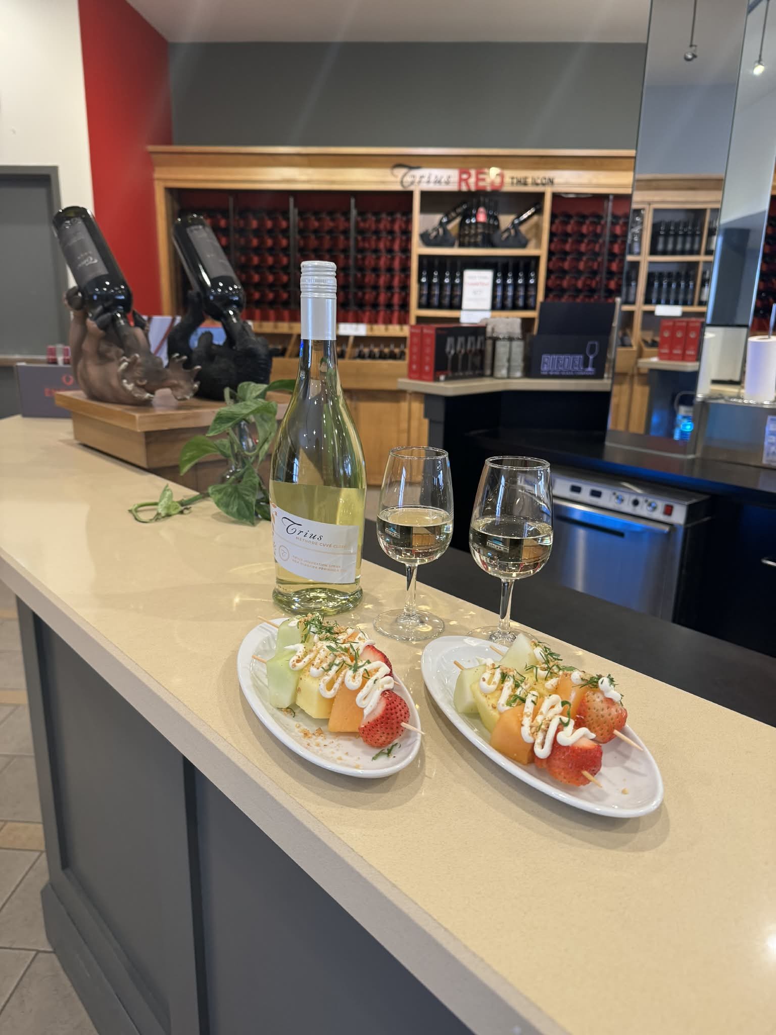 Two fruit kebabs with two glasses of Trius Winery white wine