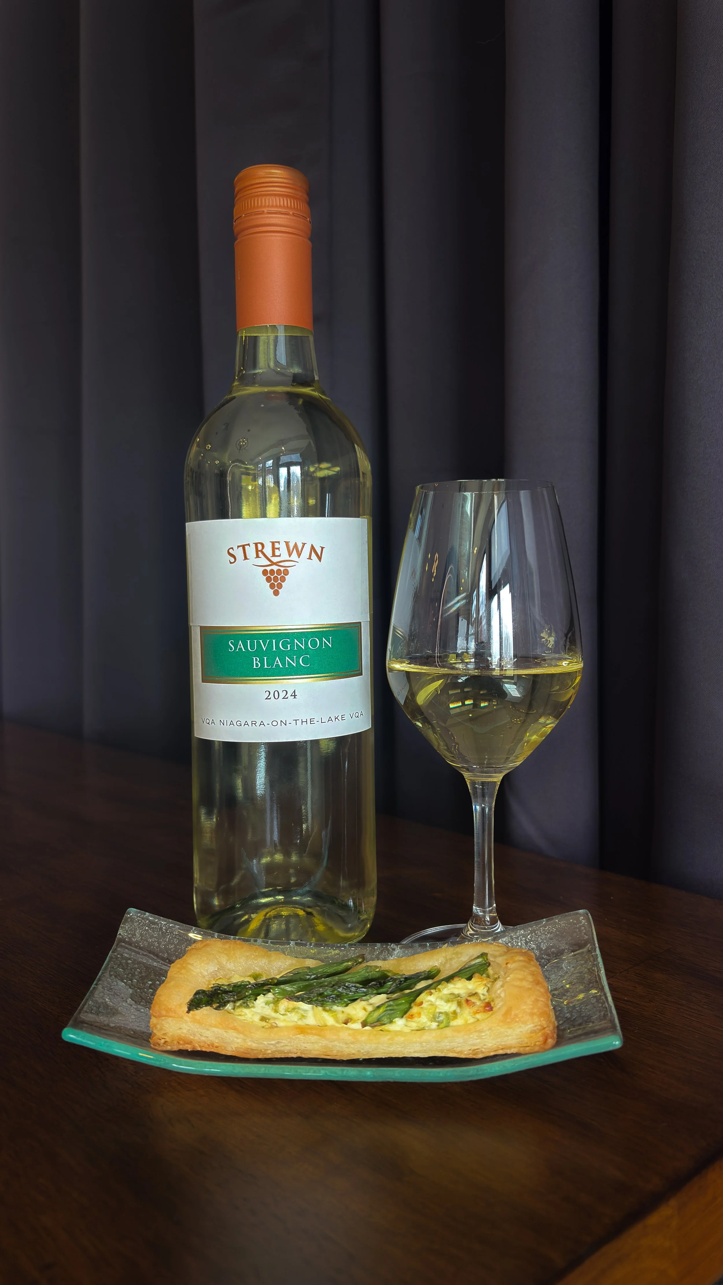A grilled asparagus and goat cheese tart with a glass of Strewn Winery Sauvignon Blanc