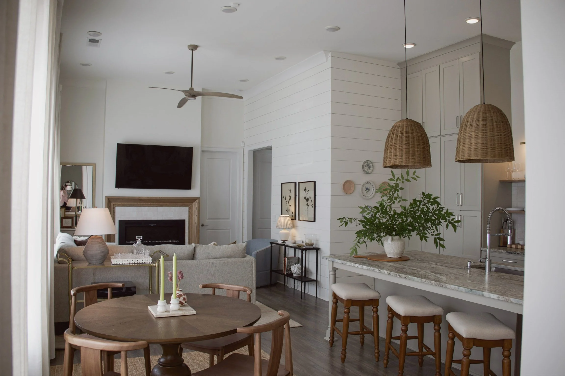 Open-concept kitchen and living area with custom cabinetry, large island, pendant lighting, and adjacent dining space.