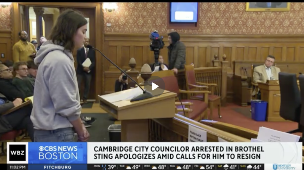 City council meeting, person speaking at podium, CBS News Boston coverage.