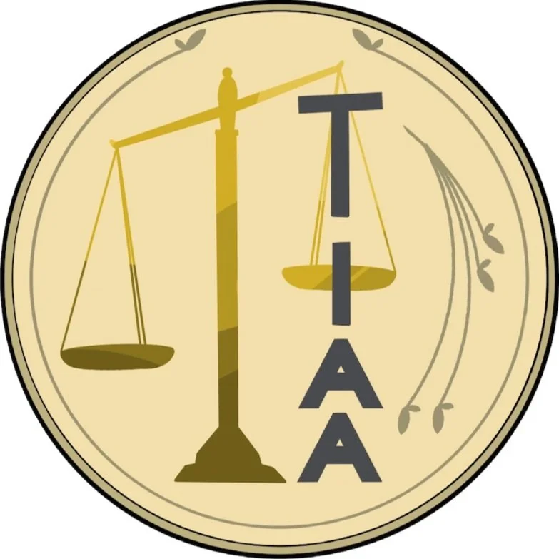 Logo featuring scales of justice and the acronym 'TIAA' on a beige background with decorative flourishes.
