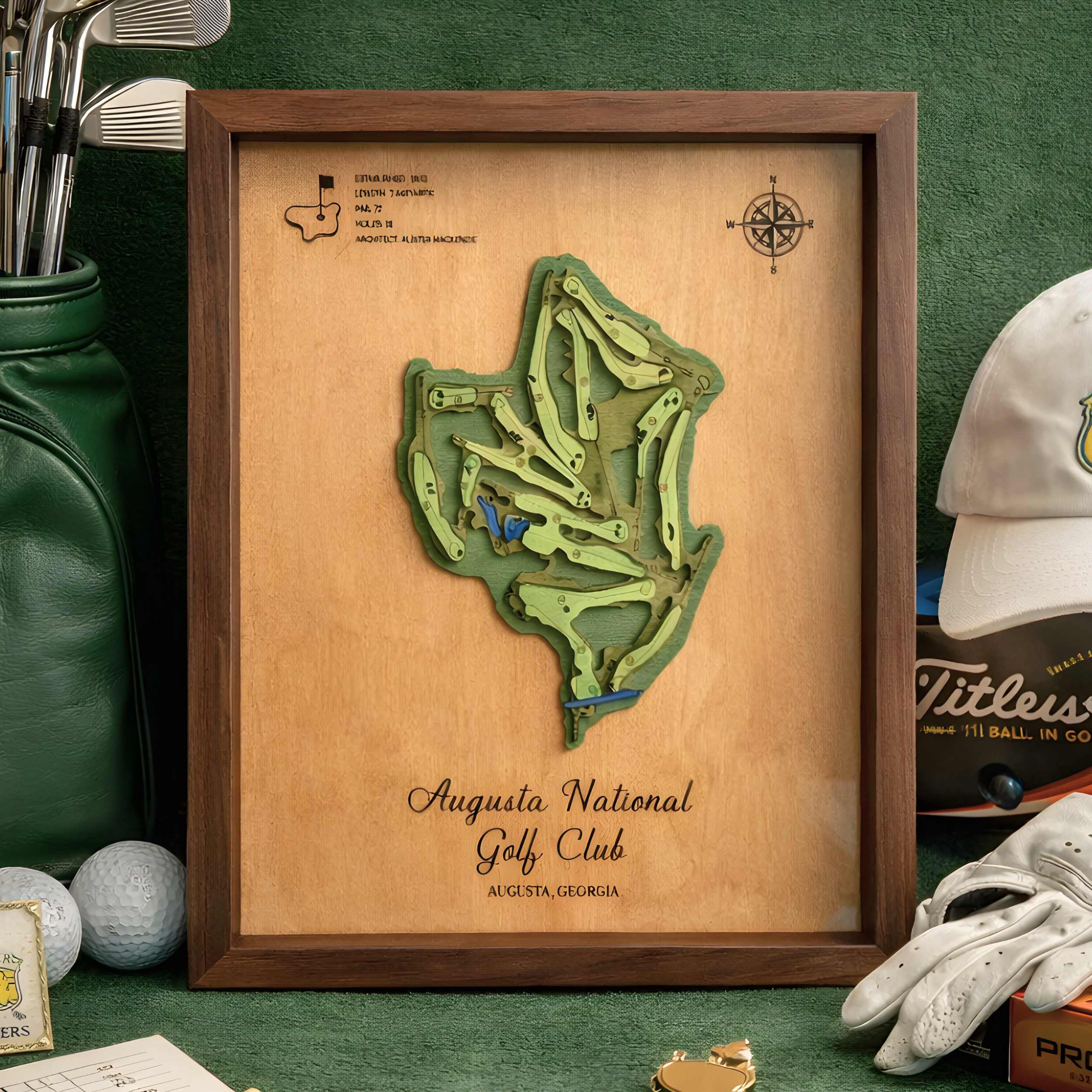 Augusta National Golf Club layered wooden course map in a dark walnut frame, staged with golf bag, clubs, balls, gloves, and hat.