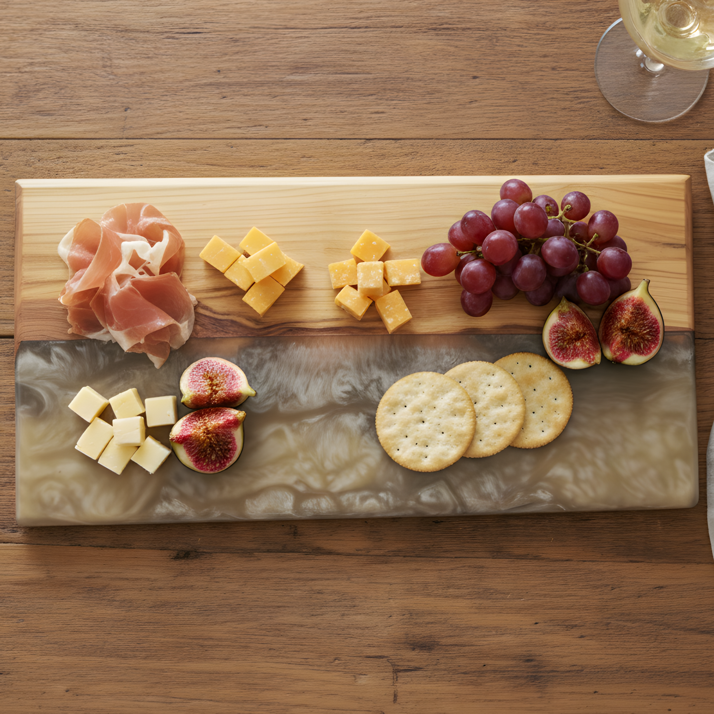 verhead view of a walnut charcuterie board with a billowing white, black, and gold epoxy river filled with cheese and fruit.