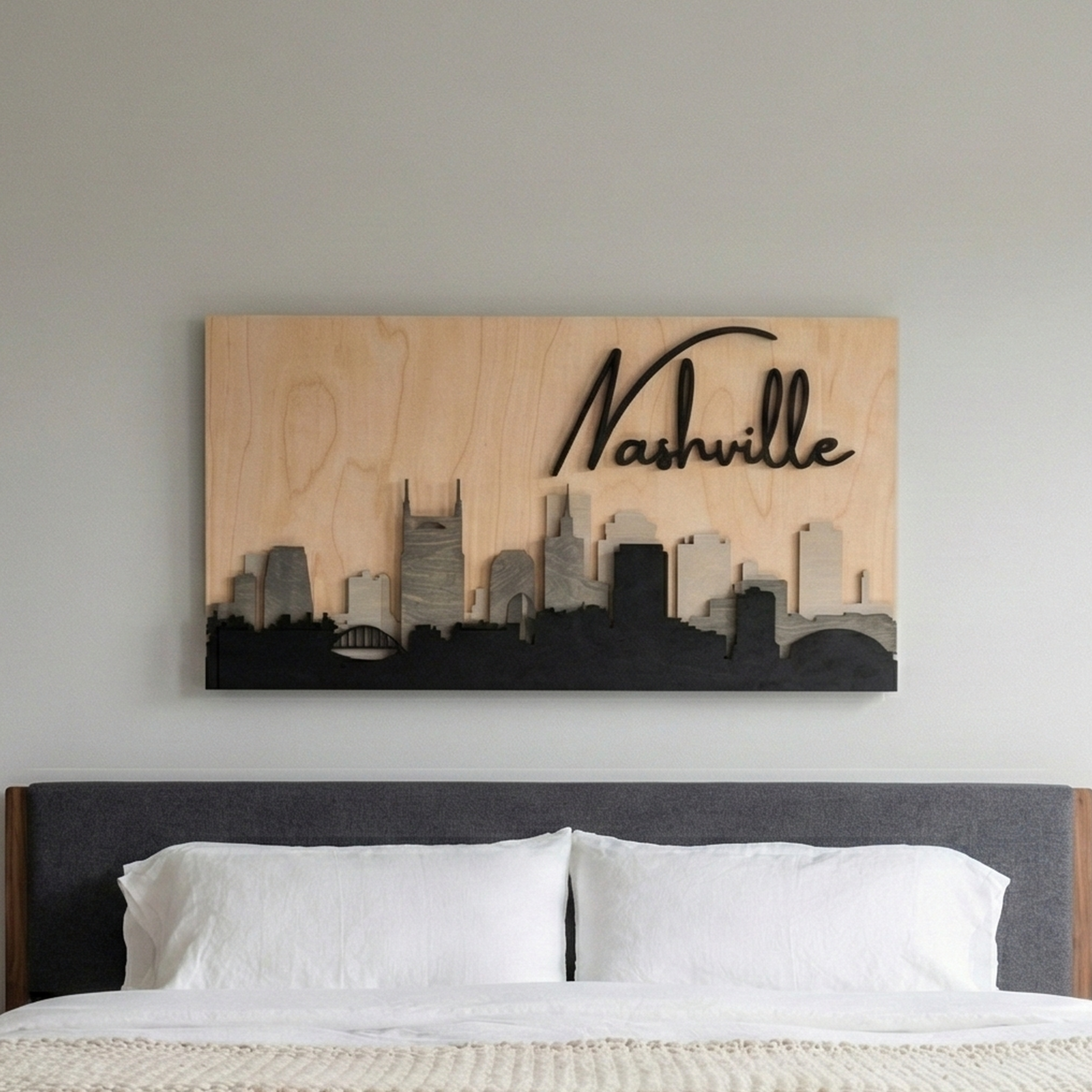 3D grey wood Nashville skyline wall art hanging on a bedroom wall above a bed with a grey headboard.