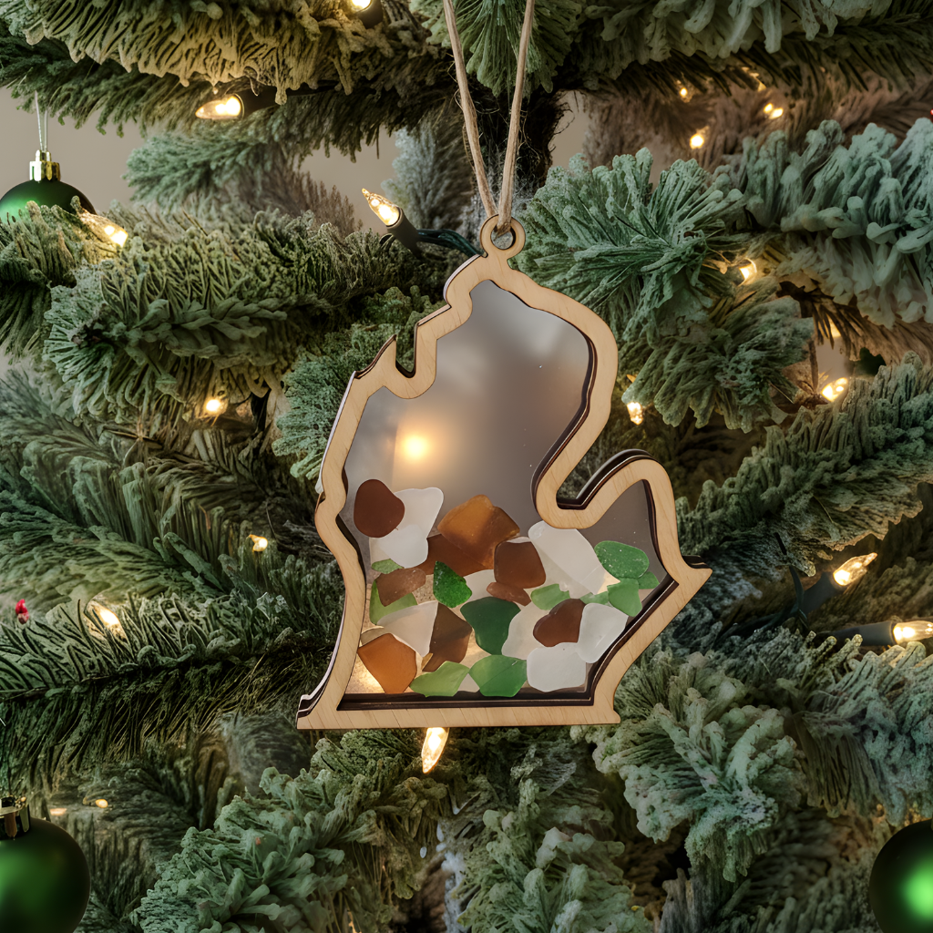 Close-up of a laser-cut Michigan wood ornament hanging by a jute string on a Christmas tree.