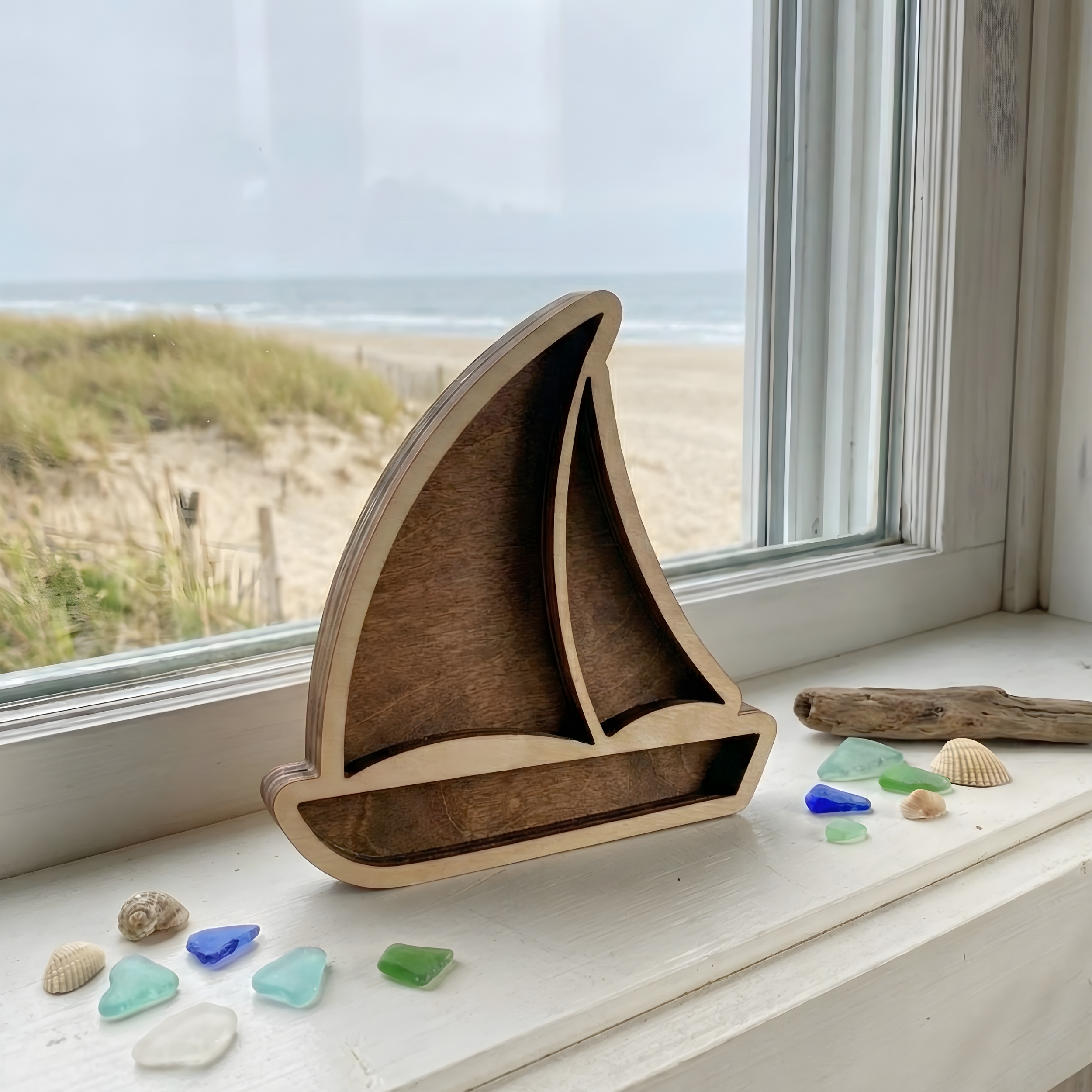 mpty sailboat-shaped wood treasure holder with a light summer oak frame displayed on a white window sill.