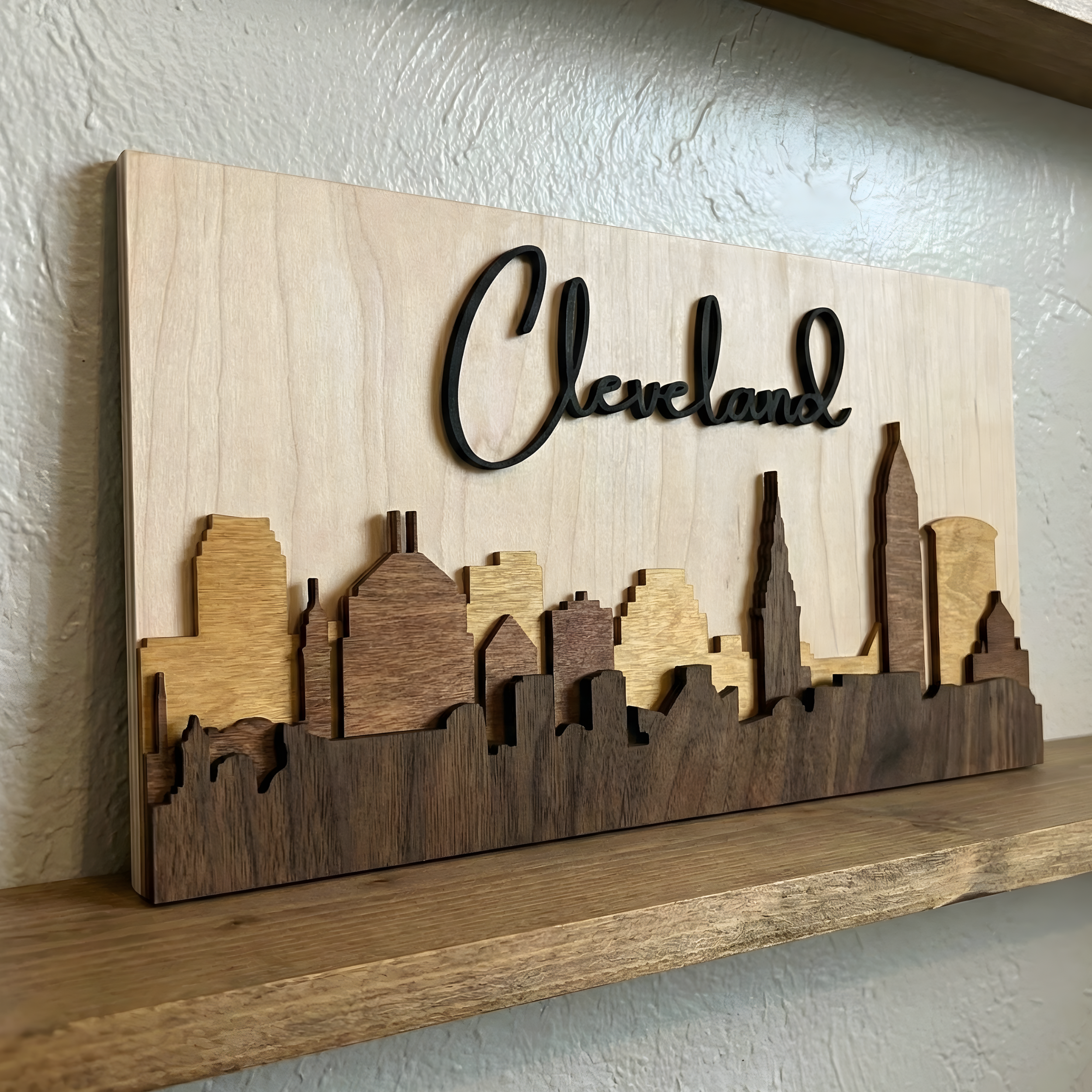 Brown layered Cleveland skyline sitting on a rustic shelf.