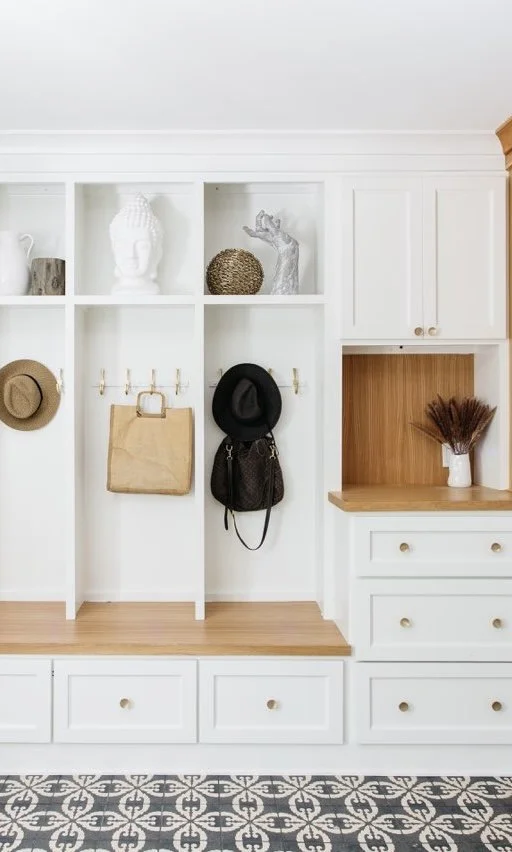 Beautiful Entry Way in Mission Hills, KS with white built-in storage with shelves and hooks, featuring hats, bags, and decorative items