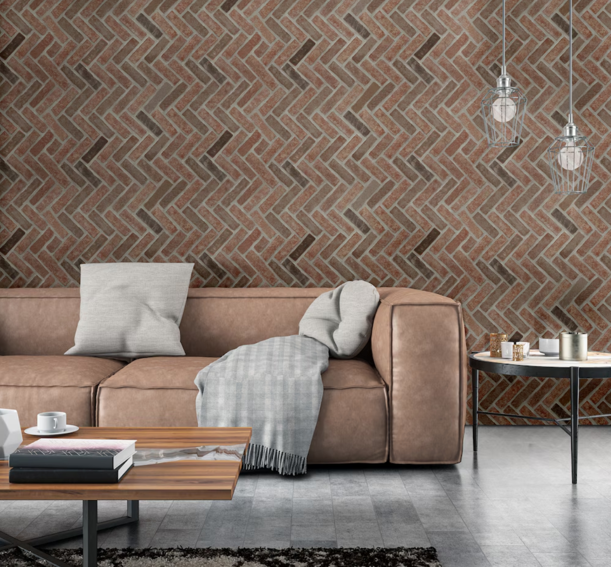 Modern living room interior with a brown leather sofa, herringbone brick wall, gray throw and pillows, coffee table with books and a cup, side table with candles and decor items, and pendant lights in Muskoka