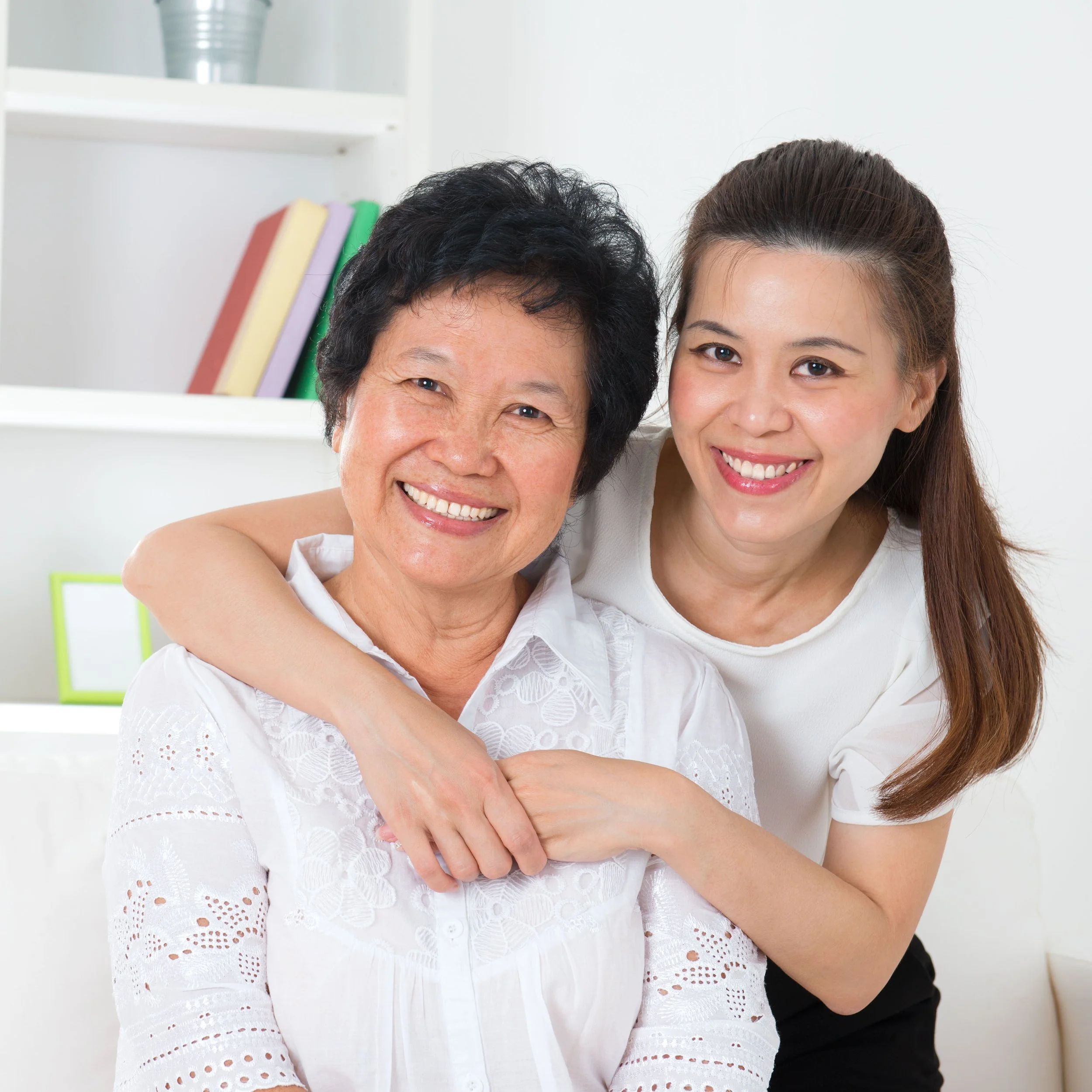 Young woman embracing her mother who may have Alzheimer's or Parkinson's disease.