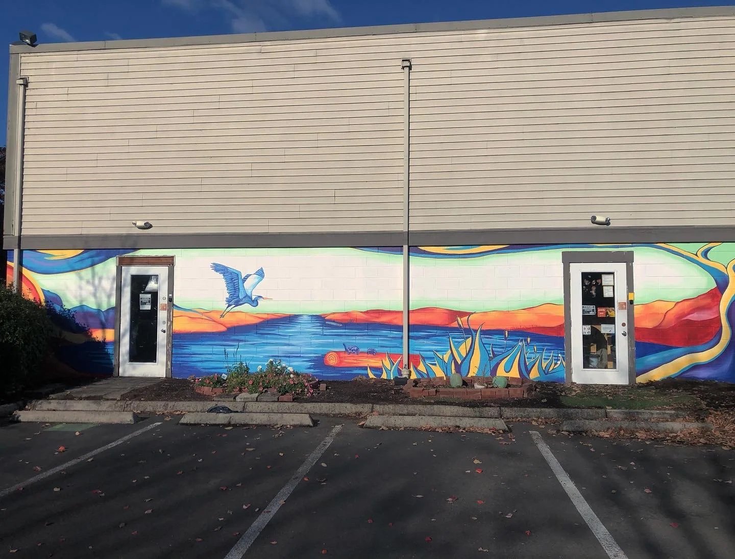 Lakeside landscape mural with heron in flight. Child Development Center East Wall, Eugene Oregon, 2021, by Brynn Gerl