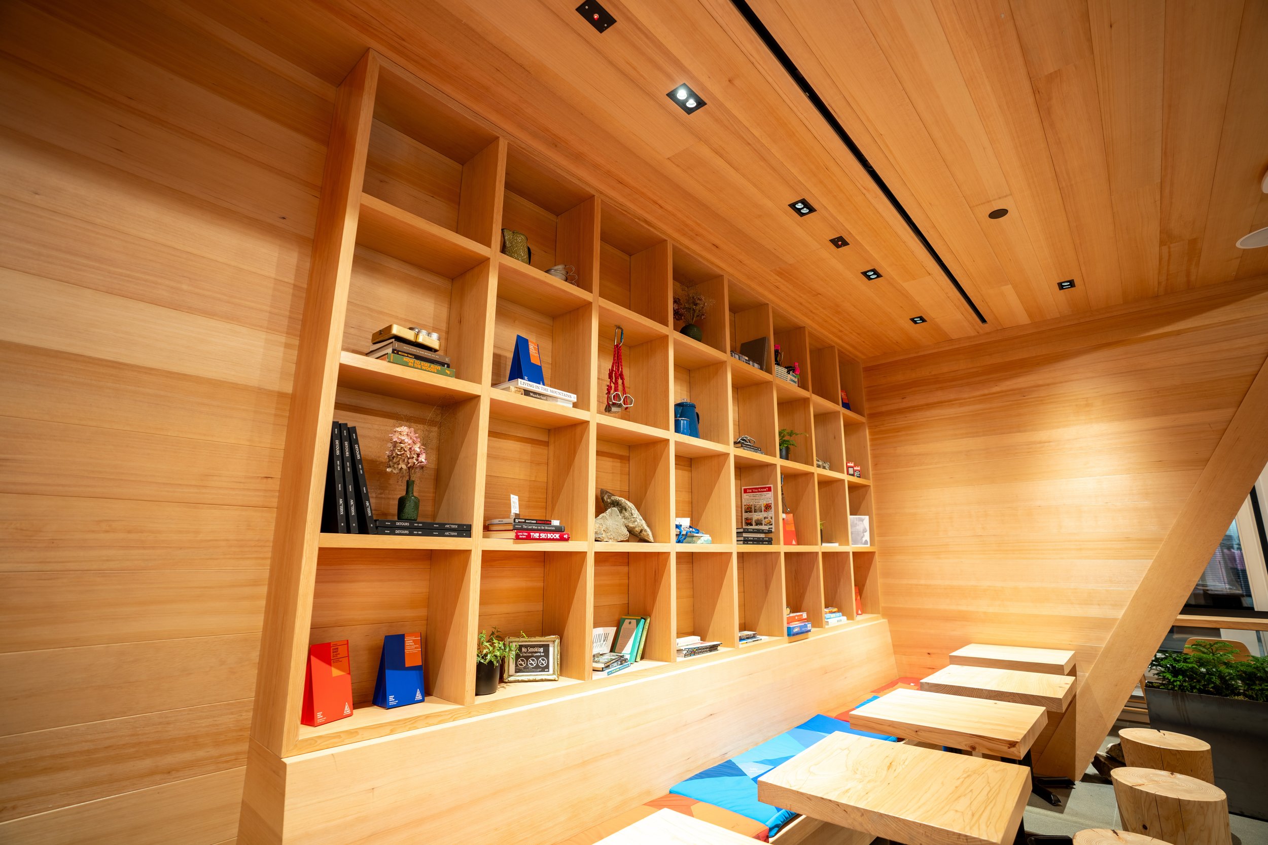 Modern wooden room with wall-mounted bookshelves and seating area