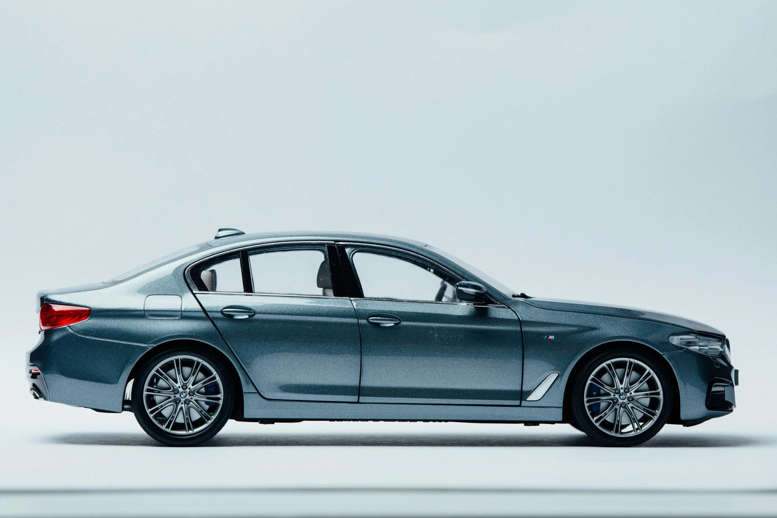 A chrome-grey sedan against a light grey background