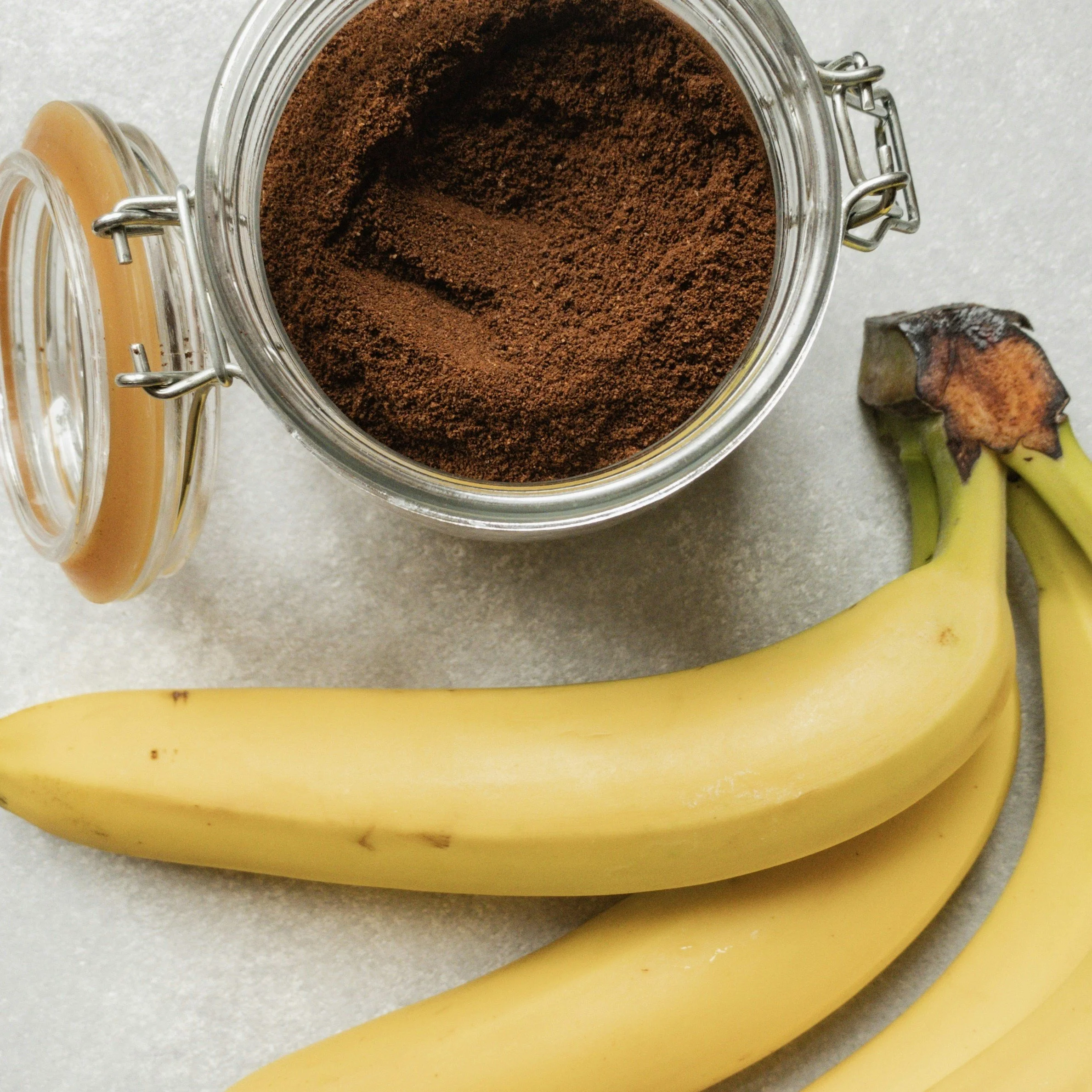 Bananas and a glass container of ground coffee
