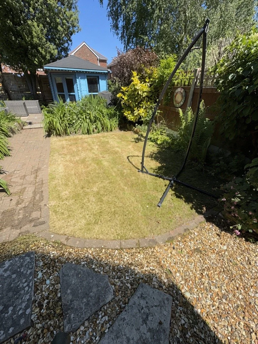 Cleared and tidy garden after maintenance, with cut grass and open space around a blue shed
