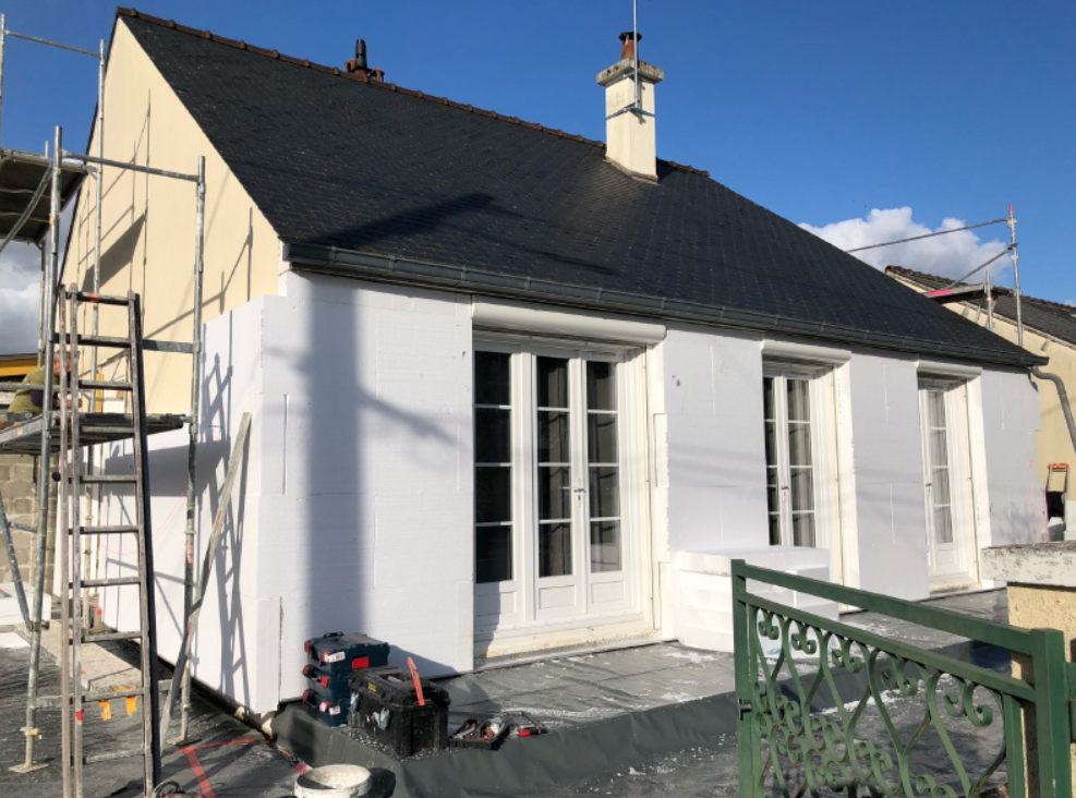 Isolation extérieure d'une maison avec des panneaux en polystyrène et échafaudage.