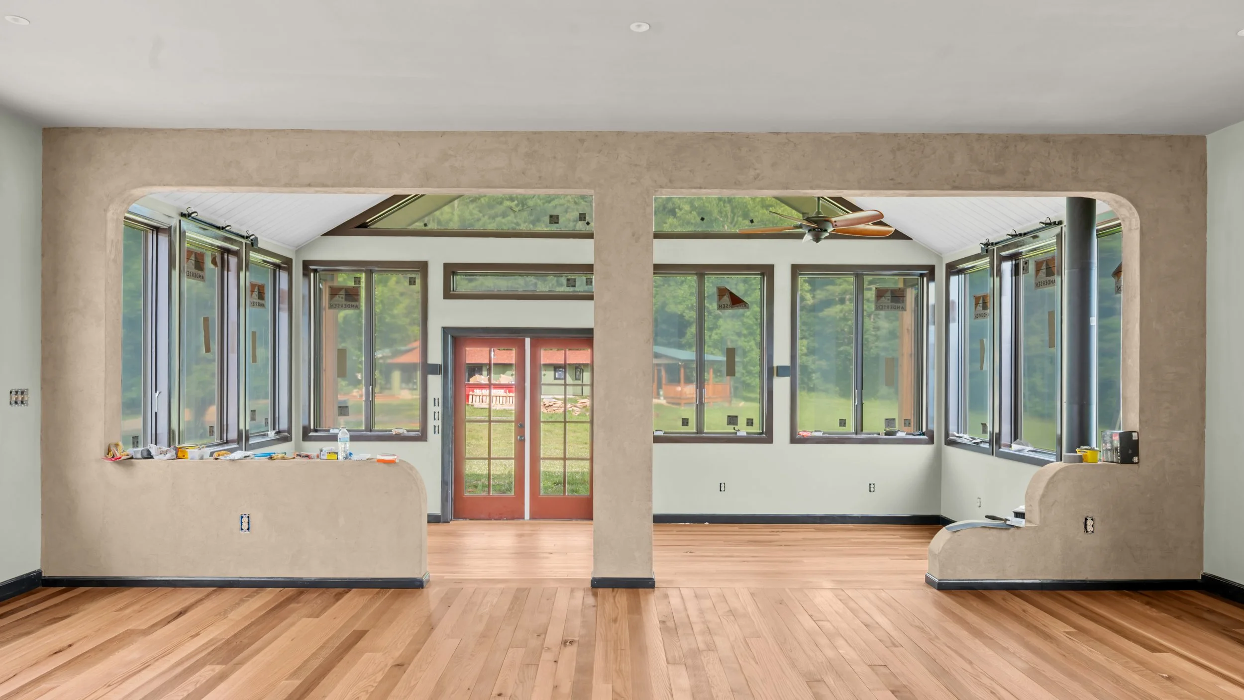 Sun-drenched great room addition with oak flooring and folding glass doors