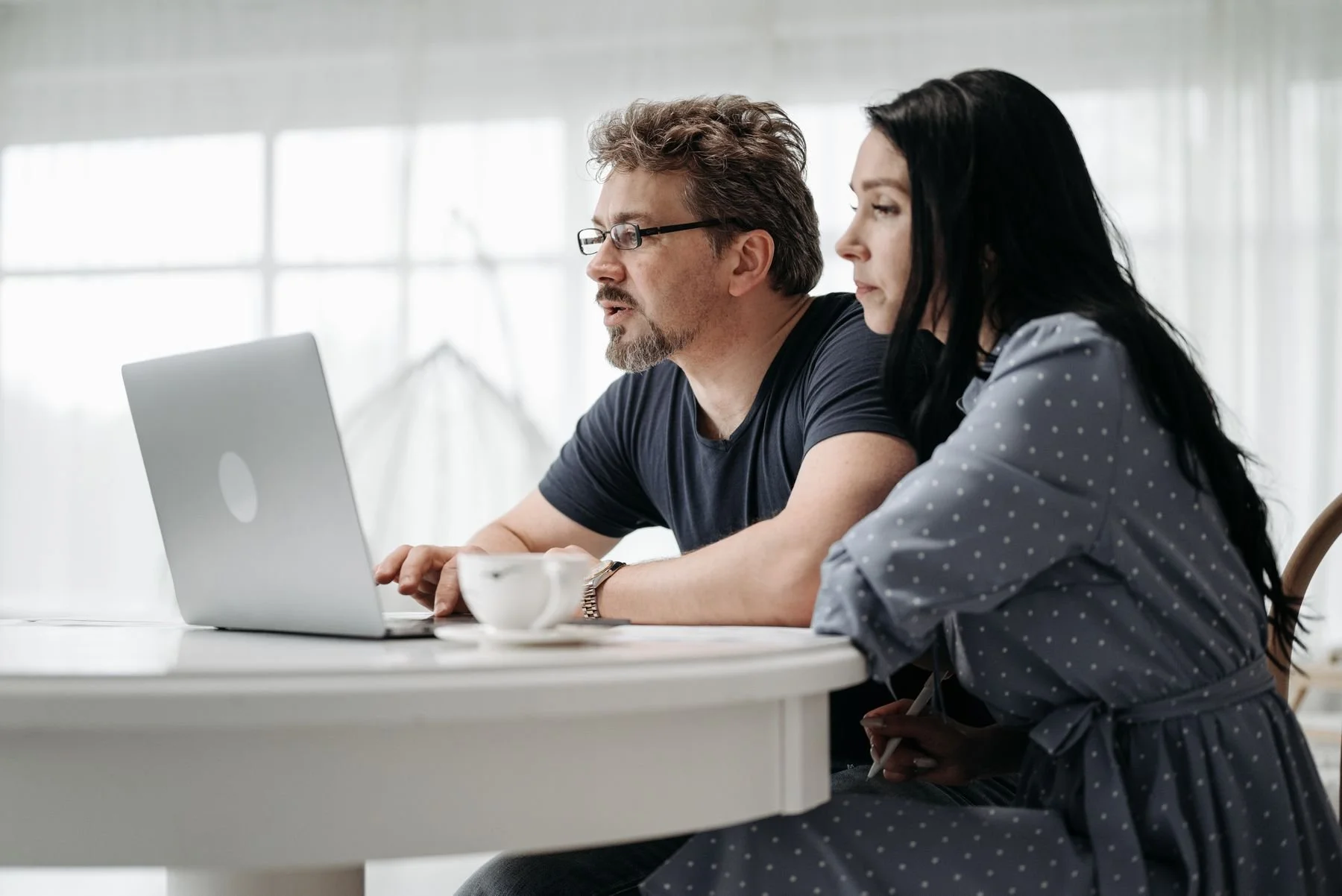 Two adults reviewing information together on a laptop.