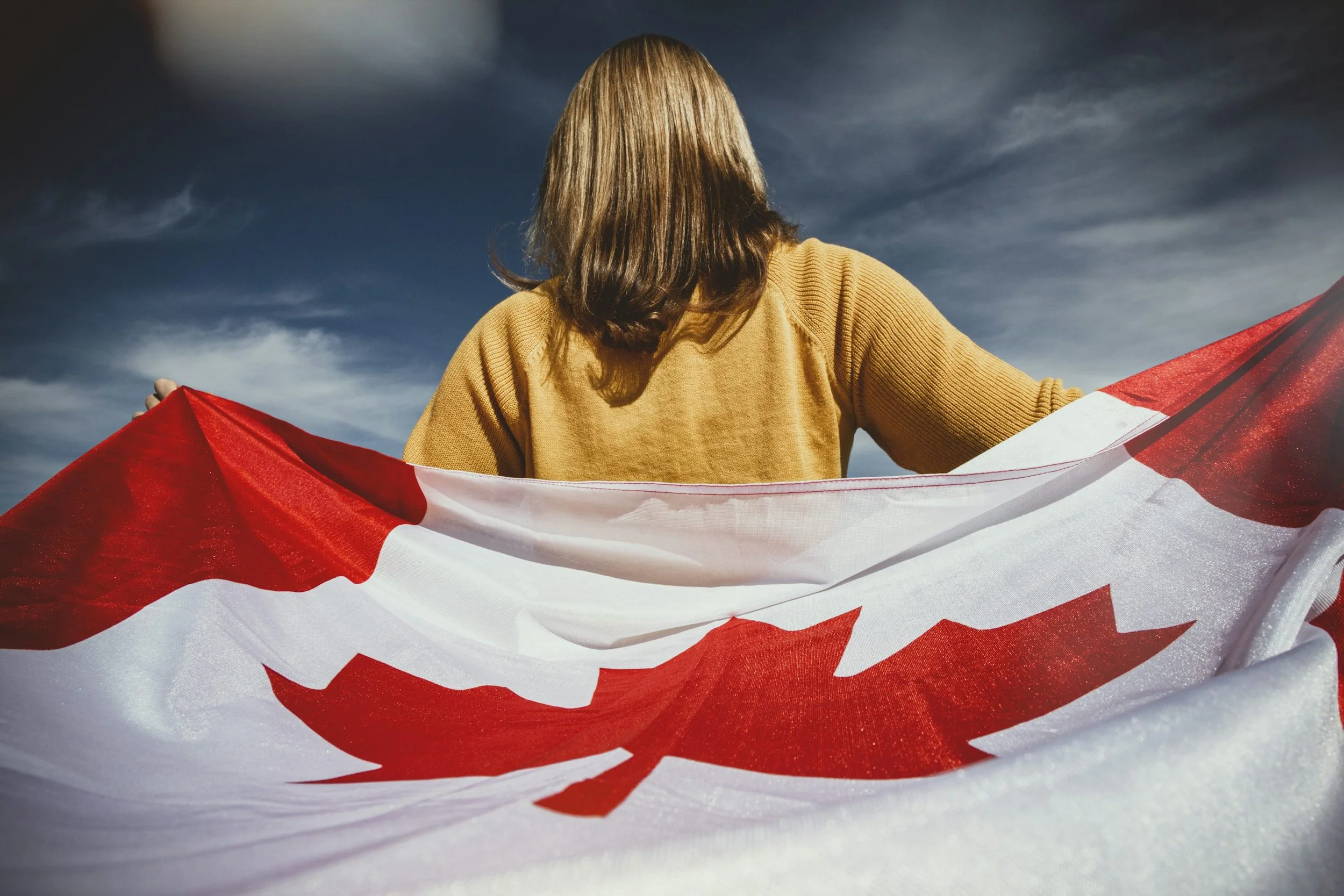 Person wrapped in a Canadian flag.