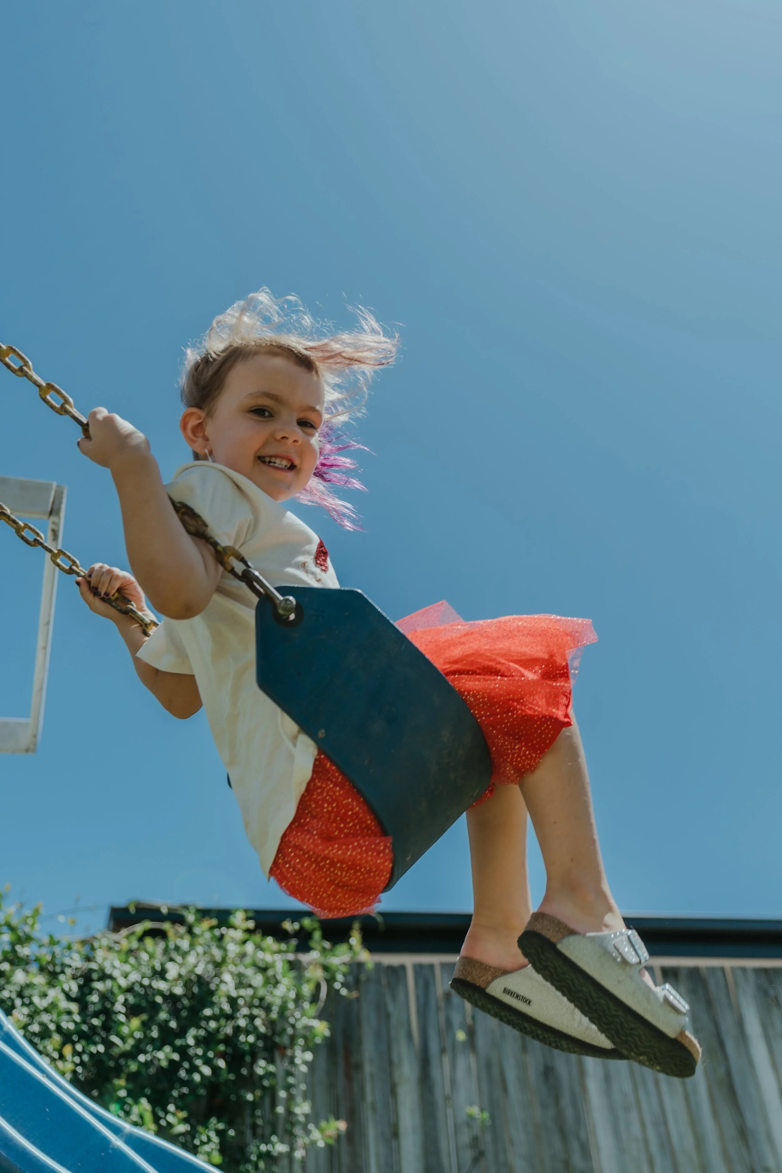 Brisbane bayside family photo shoot young girl swing backyard natural candid