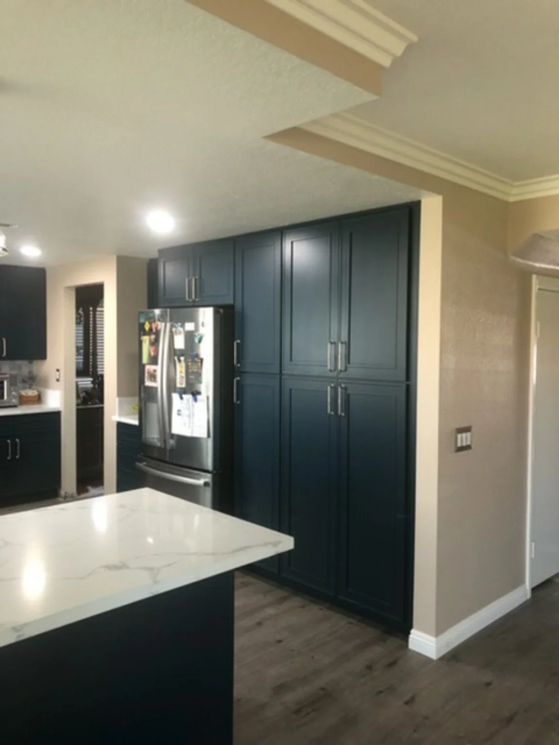 Completed residential kitchen improvement with deep navy cabinetry and light countertops