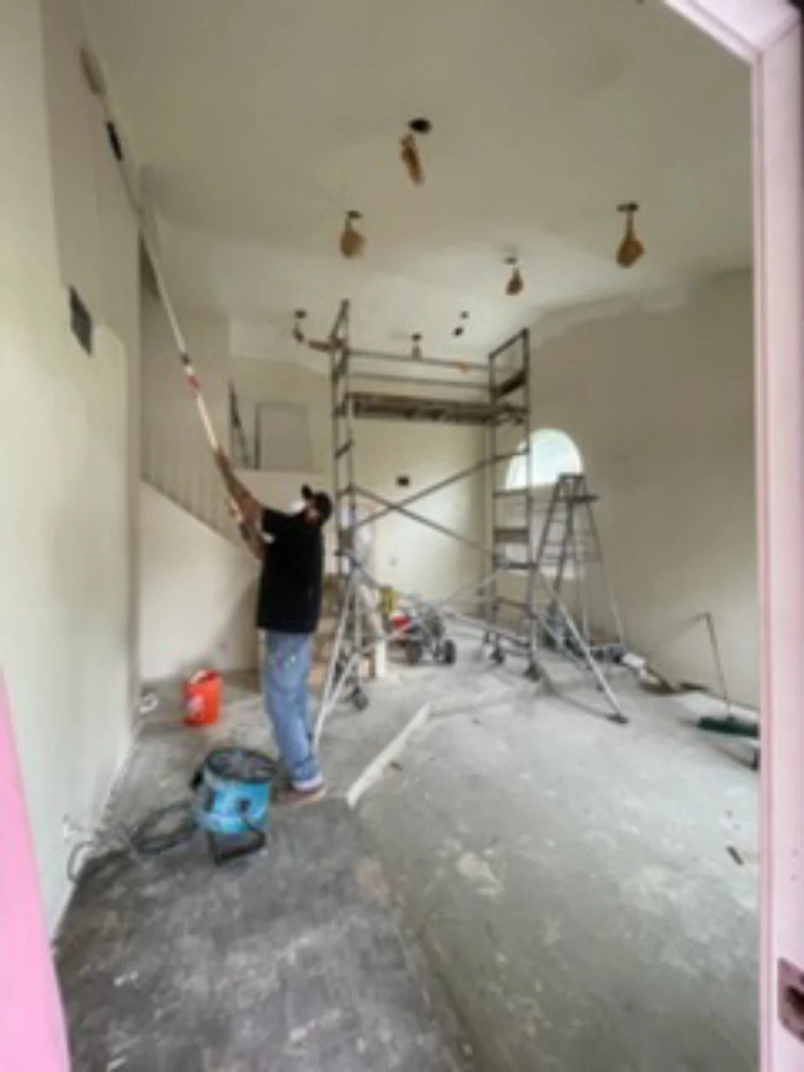 Residential interior improvement in progress with scaffolding and finish work underway
