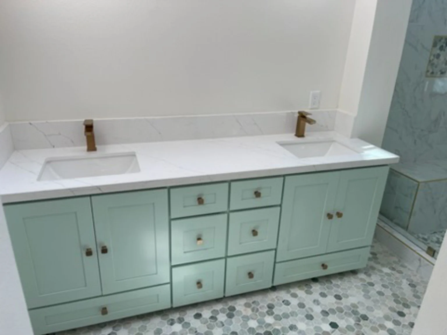 Completed residential bathroom improvement with a double vanity and patterned tile flooring