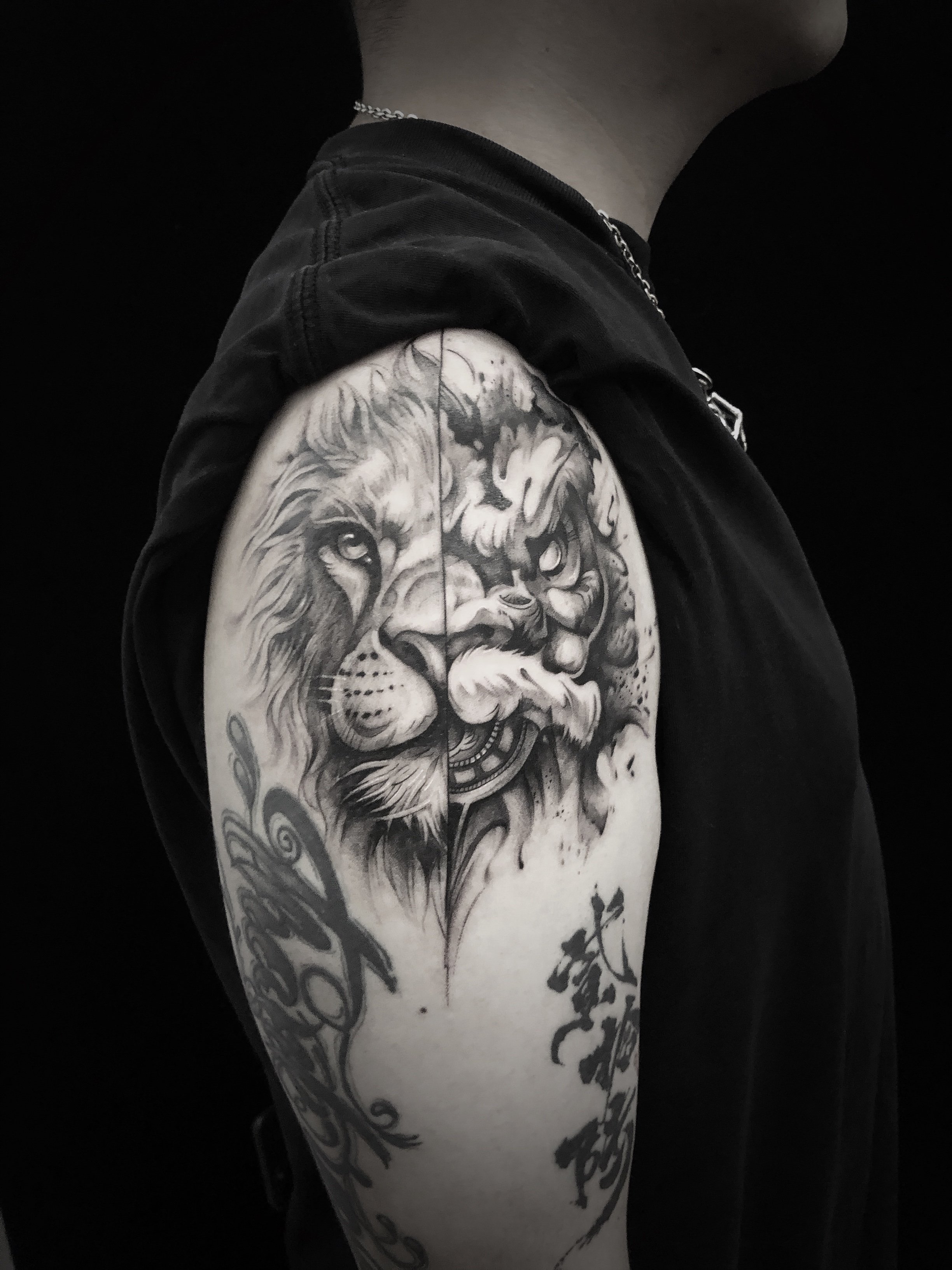 Black and gray lion and tiger tattoo on upper arm