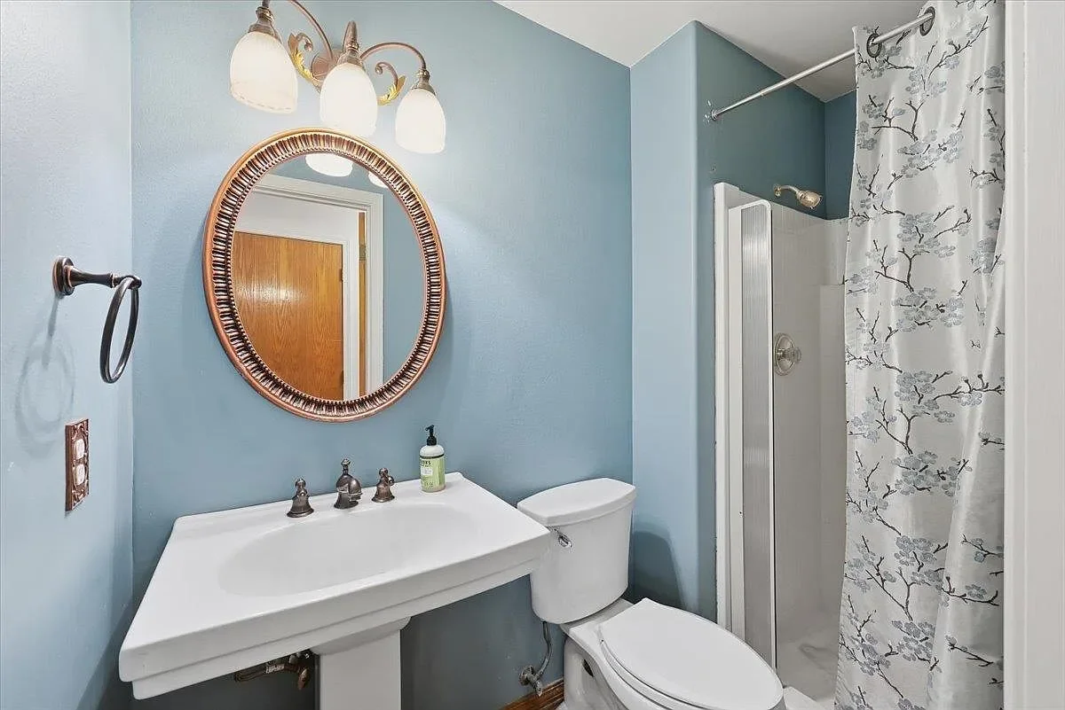 Main Floor Bathroom - Before. The original shower area was built out to accommodate a stock size shower, making an already small bathroom feel virtually unusable. 