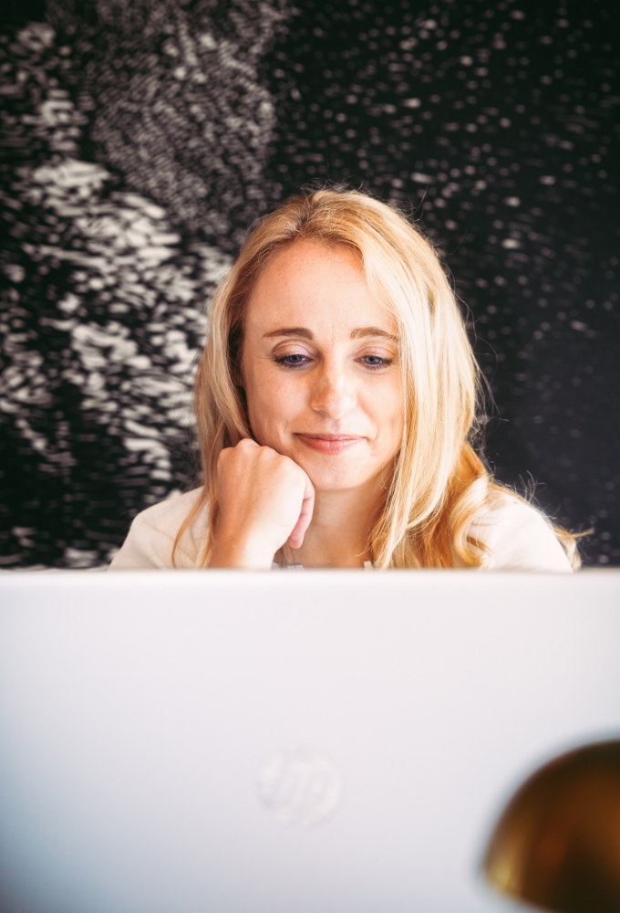 Author sitting at laptop smiling