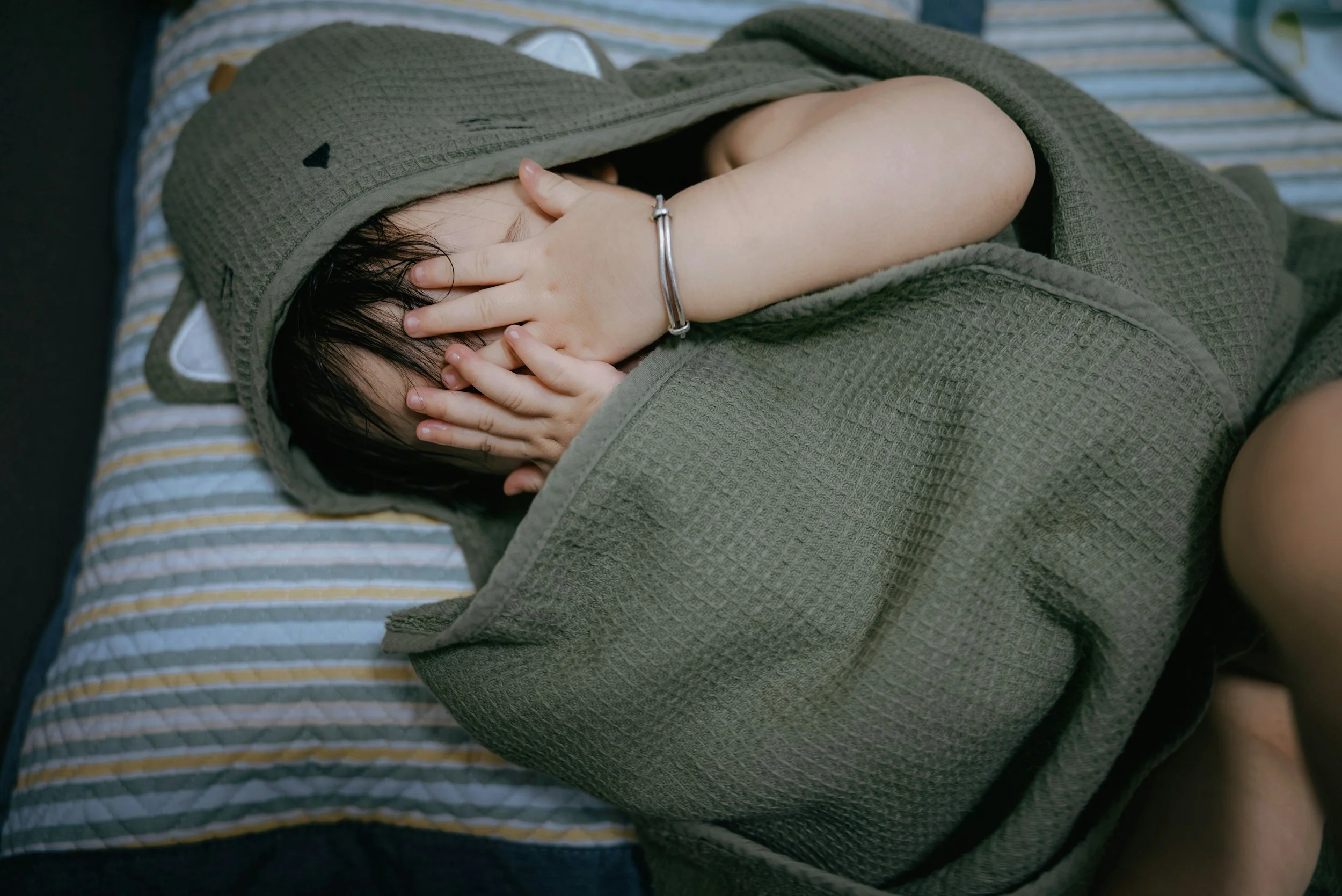 Child hiding in blanket. Comforting activities for a child with autism and overwhelmed nervouse system. A parent guide.