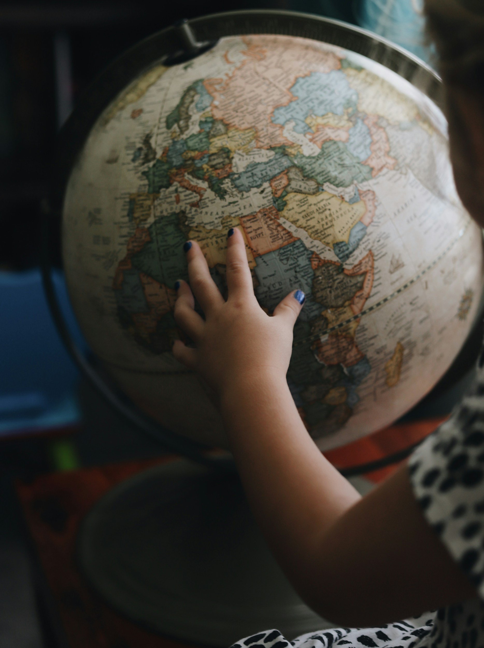 A child is using a world globe to learn geography.