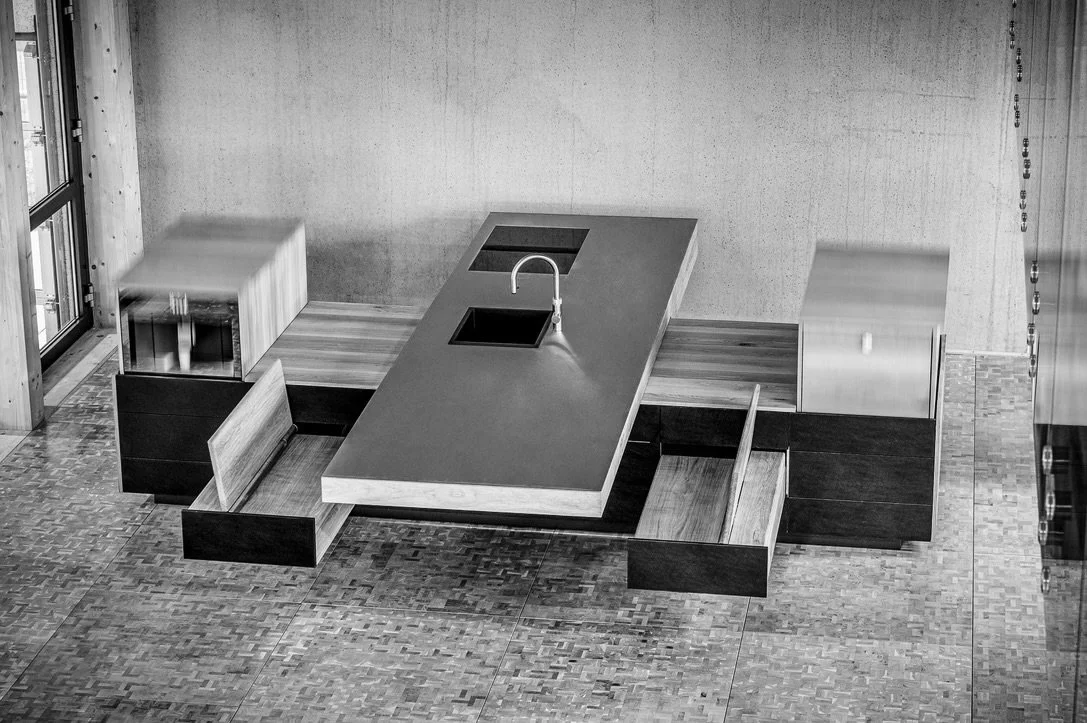 Integrated solid wood kitchen island forming the spatial centre of a contemporary living environment by IMHMV.