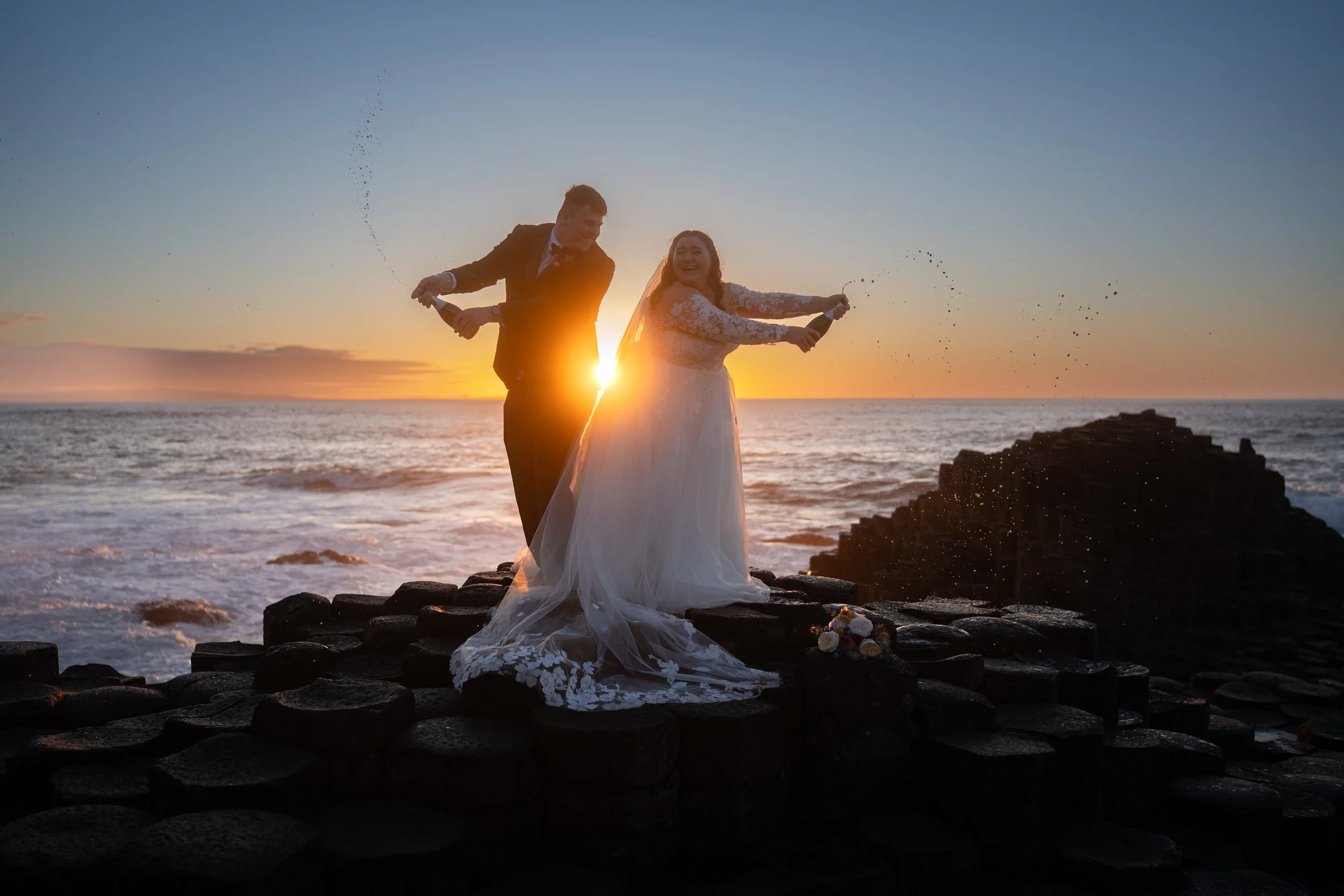 Happy Couple Kissing at The Giants Causeway with a sunset in the background