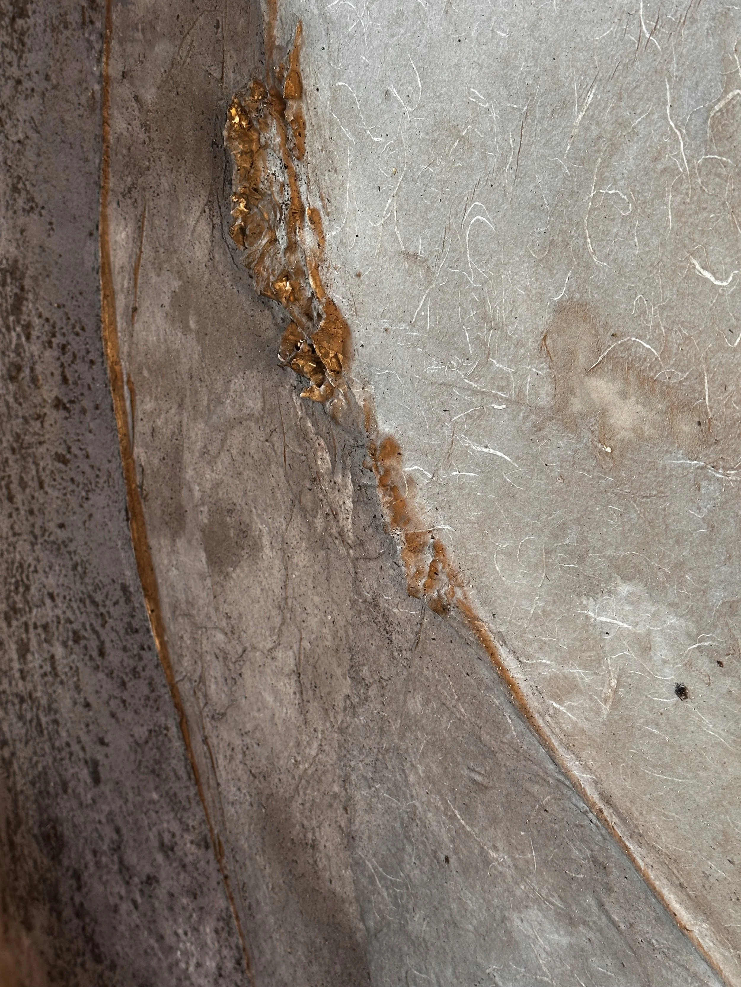 Riss im Betonboden mit rostigem Fleck.