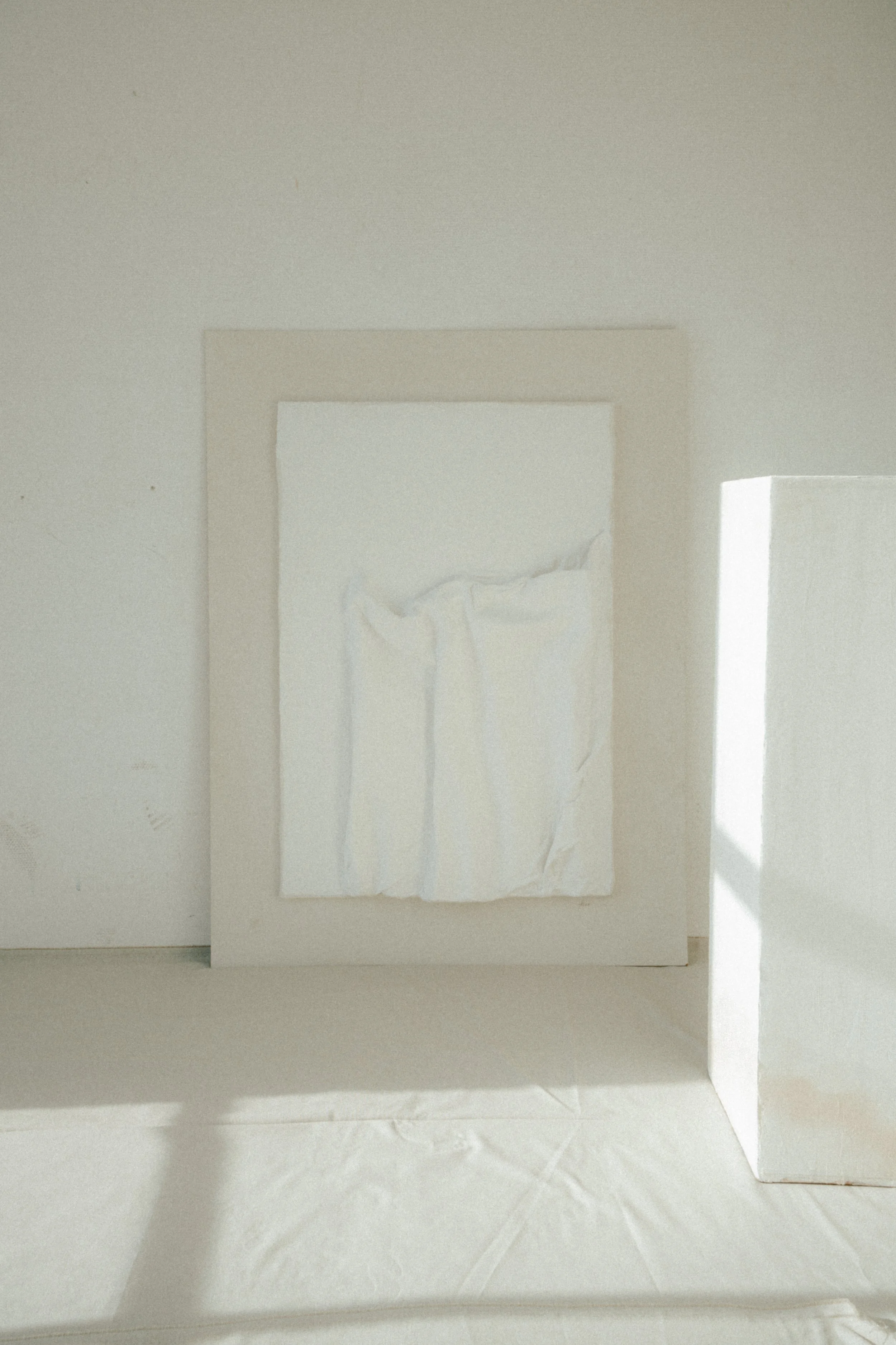 Weiße Kunstinstallation mit reliefartigem Strukturen in einem hell erleuchteten Raum.