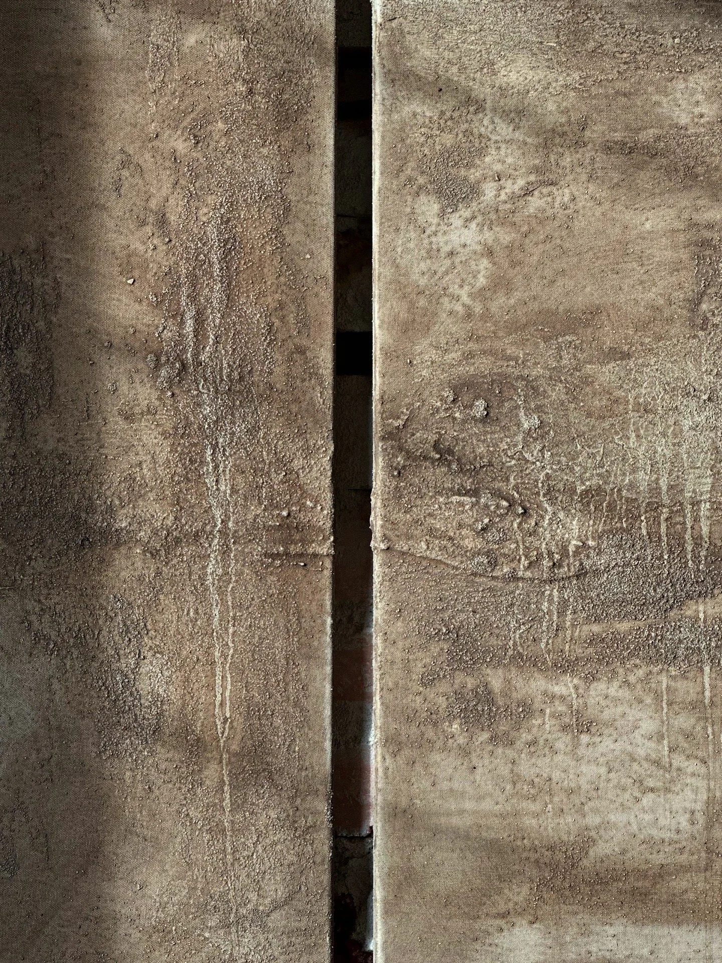 Zwei steinerne Wände mit einer schmalen Lücke zwischen ihnen.