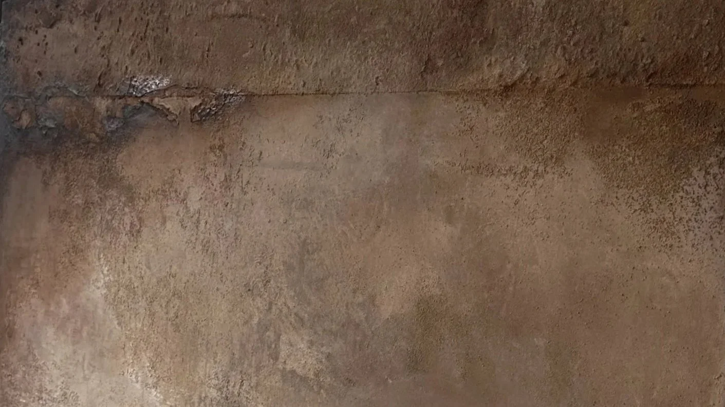 Nahaufnahme einer braunen, staubigen Wand oder Oberfläche mit unregelmäßigen Texturen