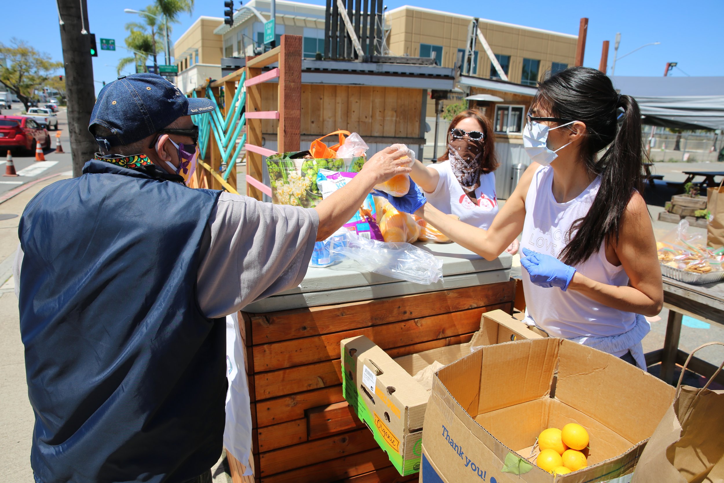 People sharing and exchanging food during a community event in Barrio Logan, San Diego.