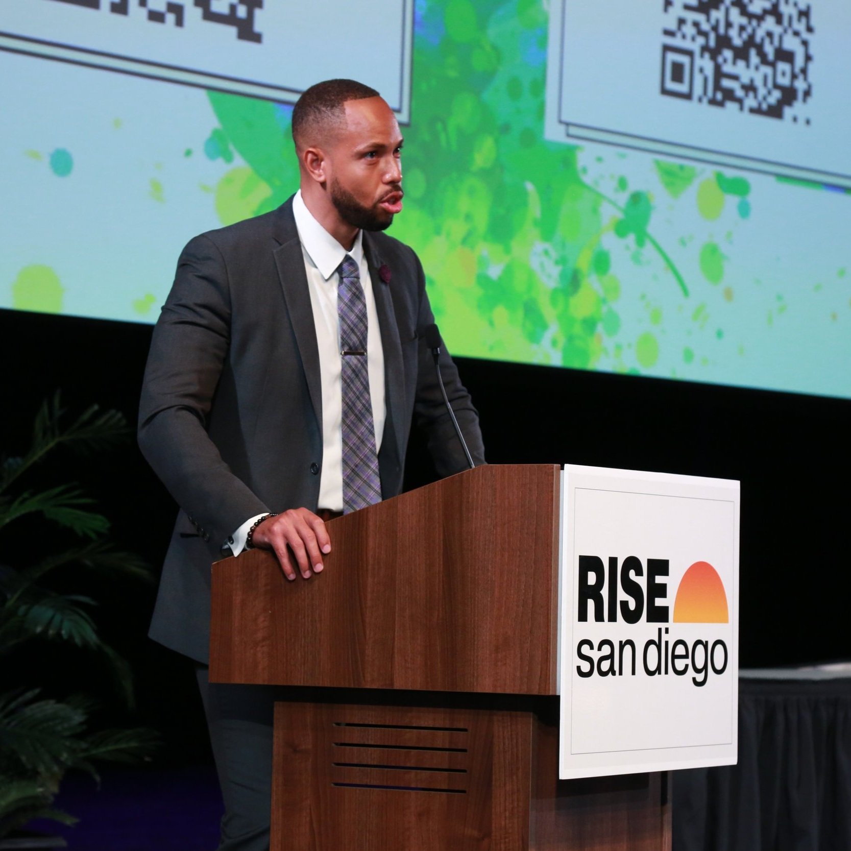 Man delivering a speech at the RISE San Diego corporate networking event, showcasing business leadership.