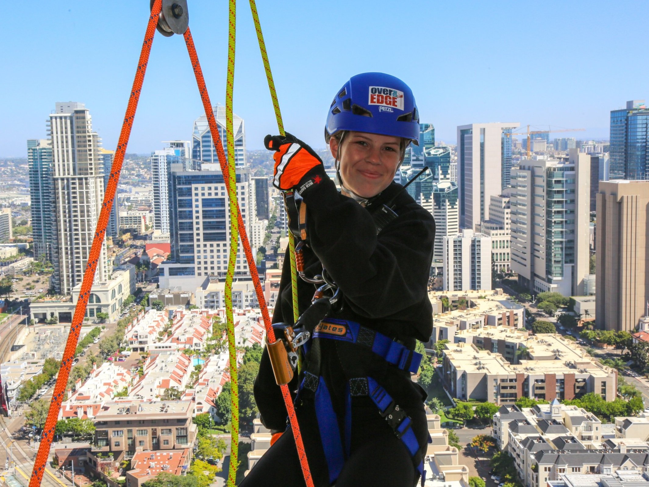 Woman preparing for a hotel building rappel in downtown San Diego, ready for an adventure activity.