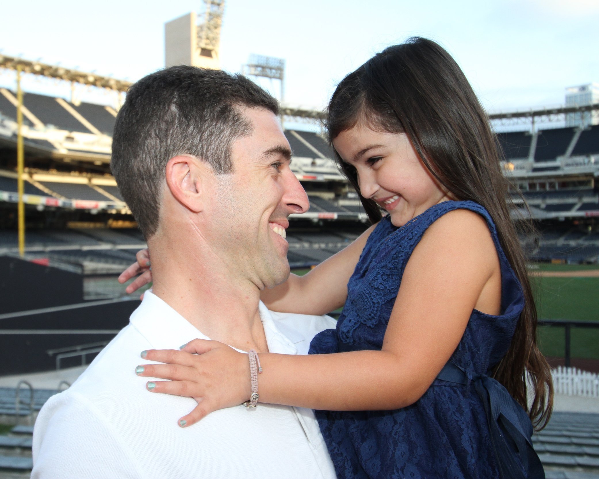Father and daughter posing together in front of Petco Park in San Diego, capturing a special moment at the baseball stadium.
