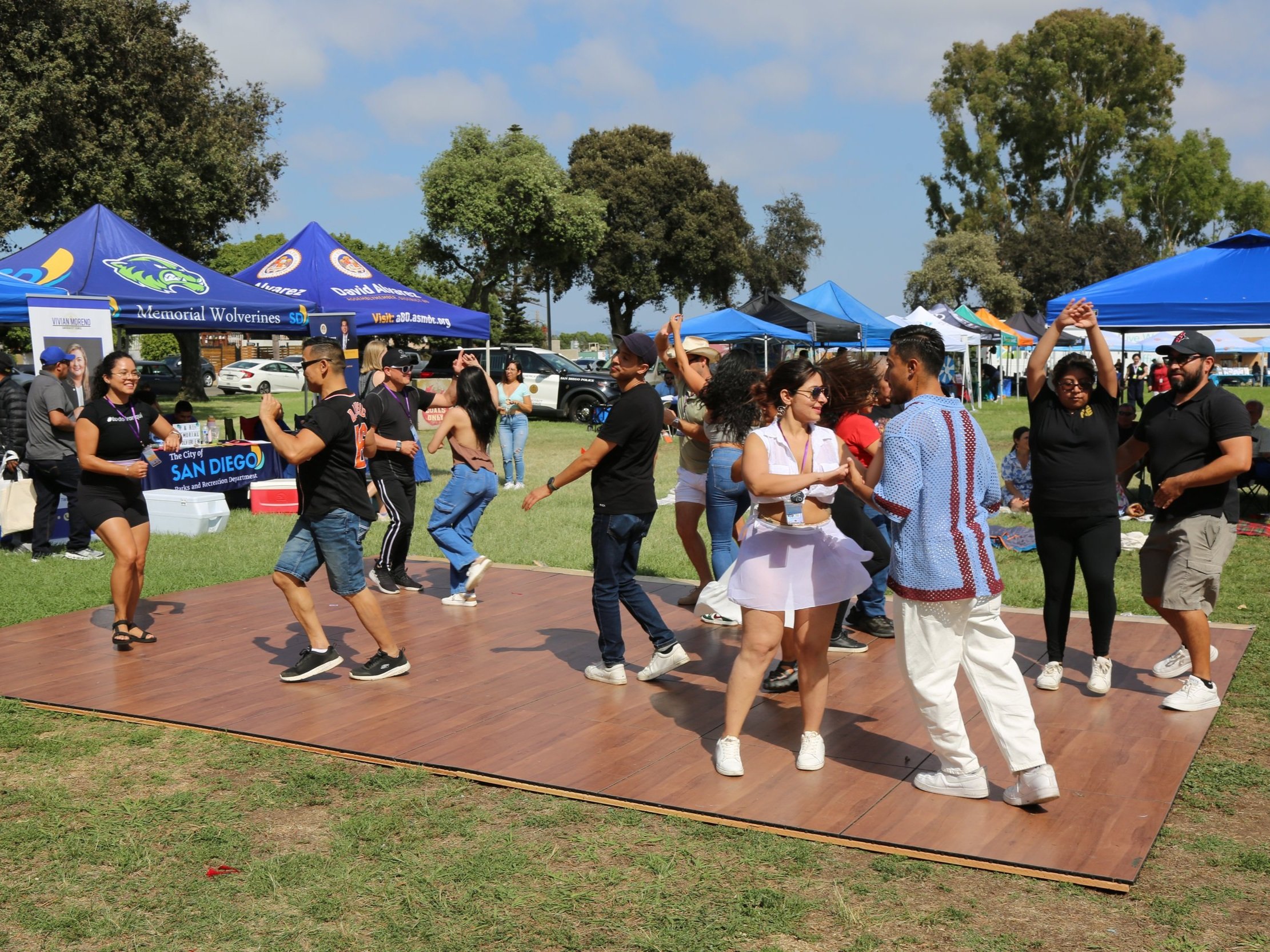 Community members dancing together at a vibrant cultural event in San Diego.
