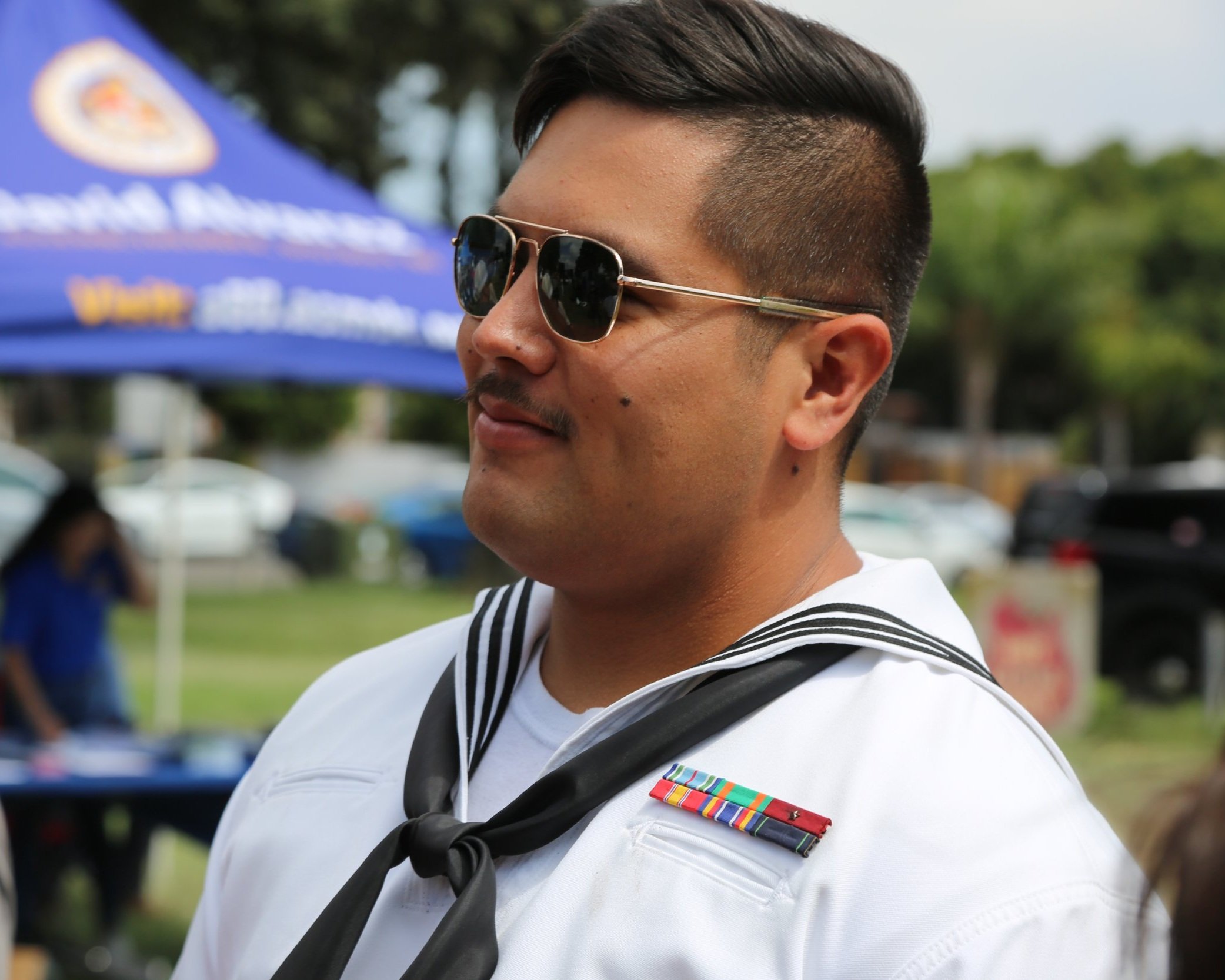 Navy sailor interacting with community members at a public event in San Diego.