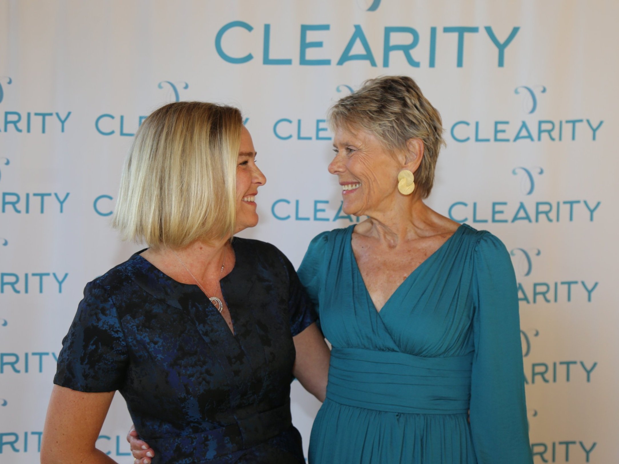 Women smiling and connecting at a community fundraising event in San Diego, supporting local causes.