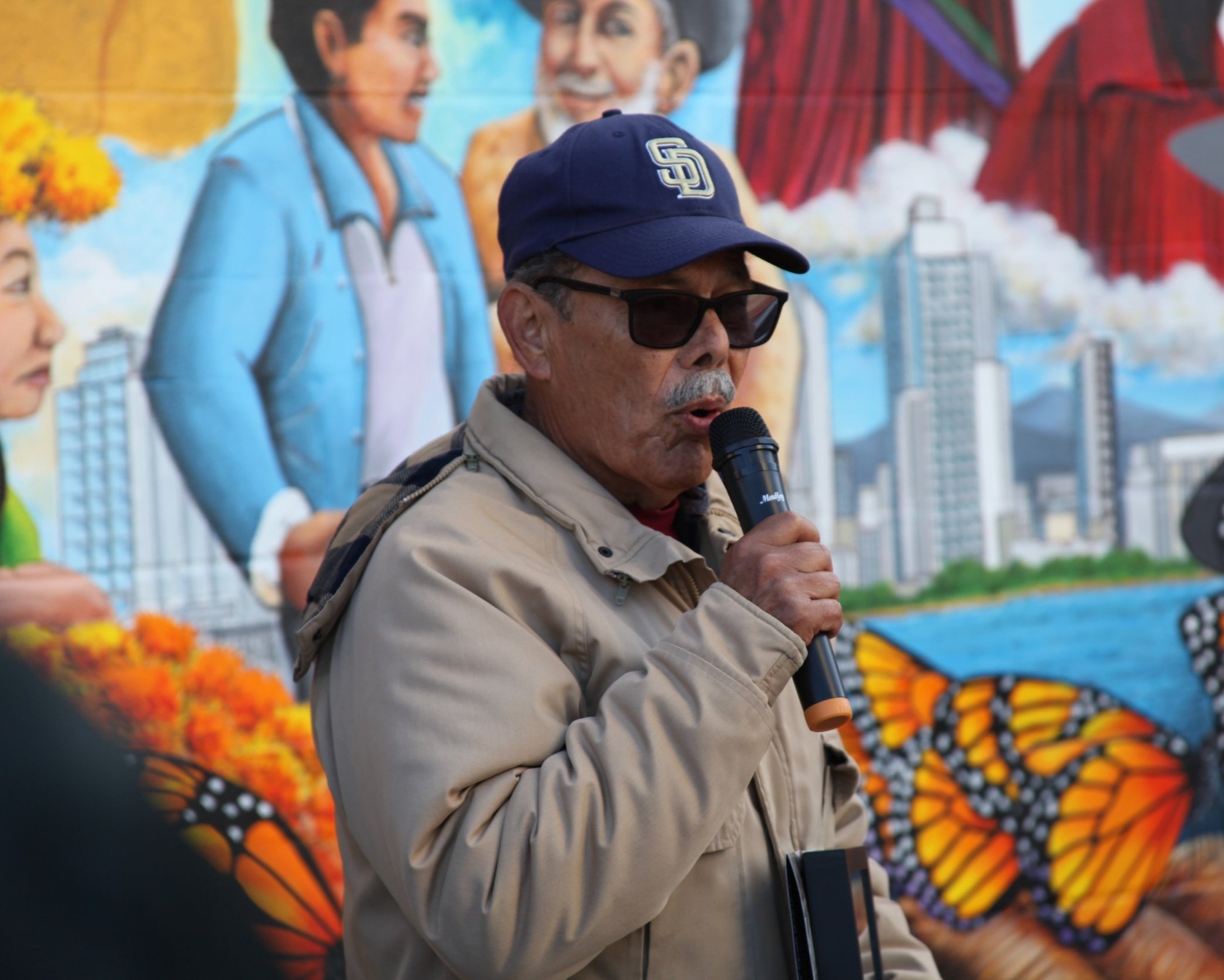 Muralist addressing attendees at a community event in National City, San Diego, discussing local artwork and public art projects.