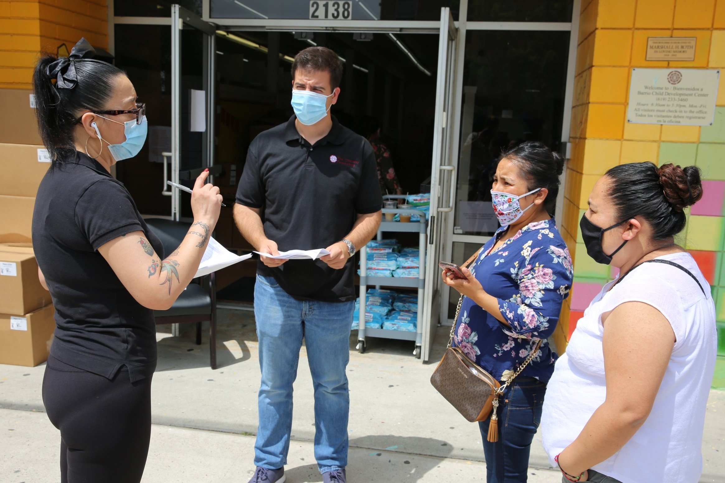 Employees and volunteers coordinating and participating in a community event in Barrio Logan, San Diego.
