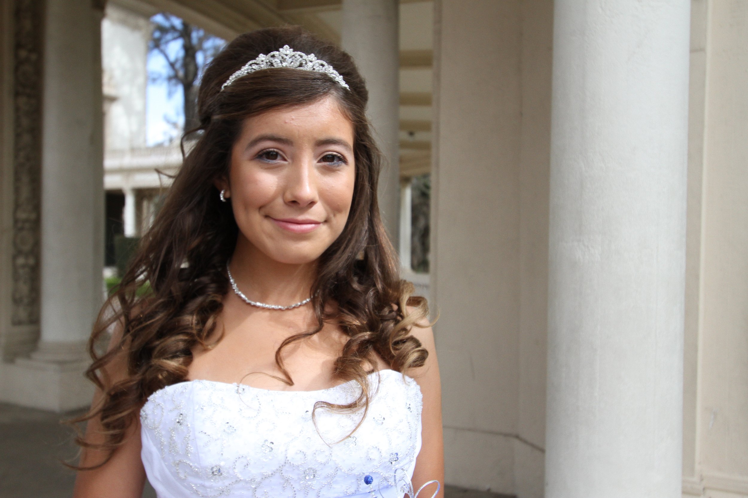 Smiling Quinceañera girl during her photoshoot in San Diego, celebrating her special milestone with family and friends.